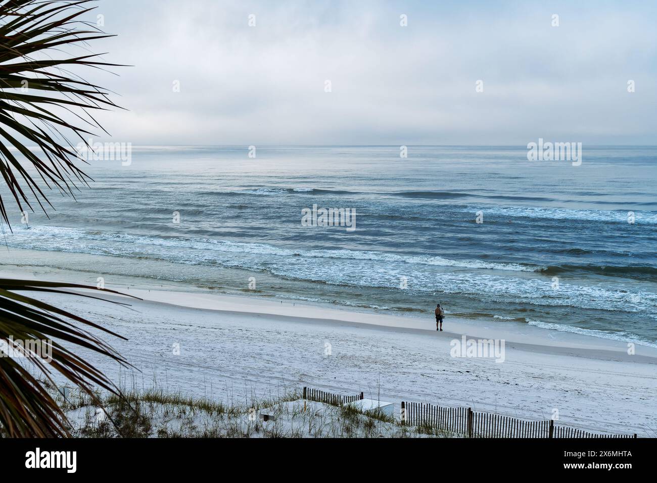 Pêcheur ou homme sur une plage vide à l'aube pêche à la mouche dans le golfe du Mexique à destin Florida, USA. Banque D'Images