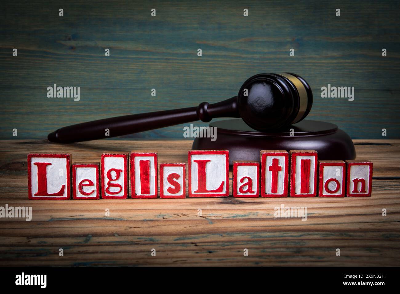 LÉGISLATION. Lettres de l'alphabet rouge et marteau de juge sur fond de bois. Droit et concept de justice. Banque D'Images