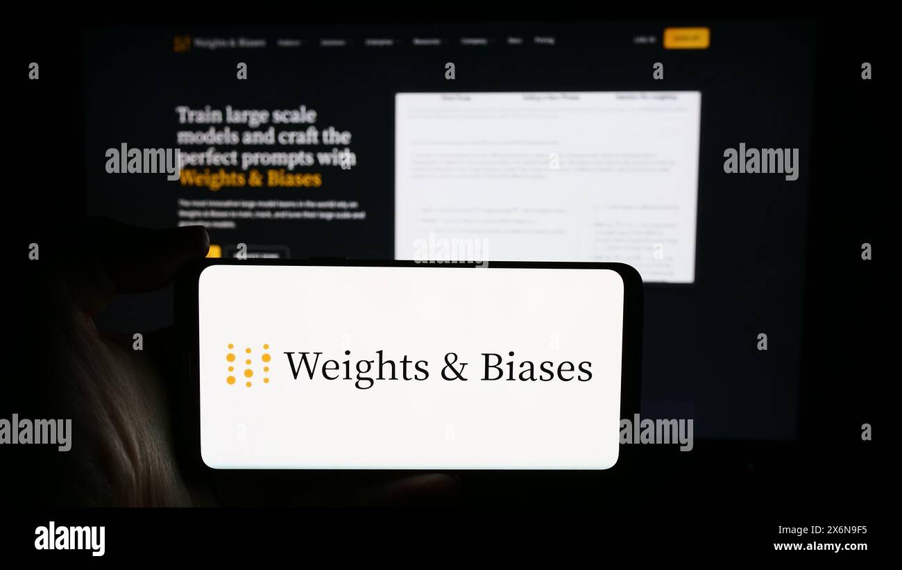 Personne tenant un téléphone portable avec le logo de la société d'intelligence artificielle américaine poids et biais Inc devant la page Web. Concentrez-vous sur l'affichage du téléphone. Banque D'Images