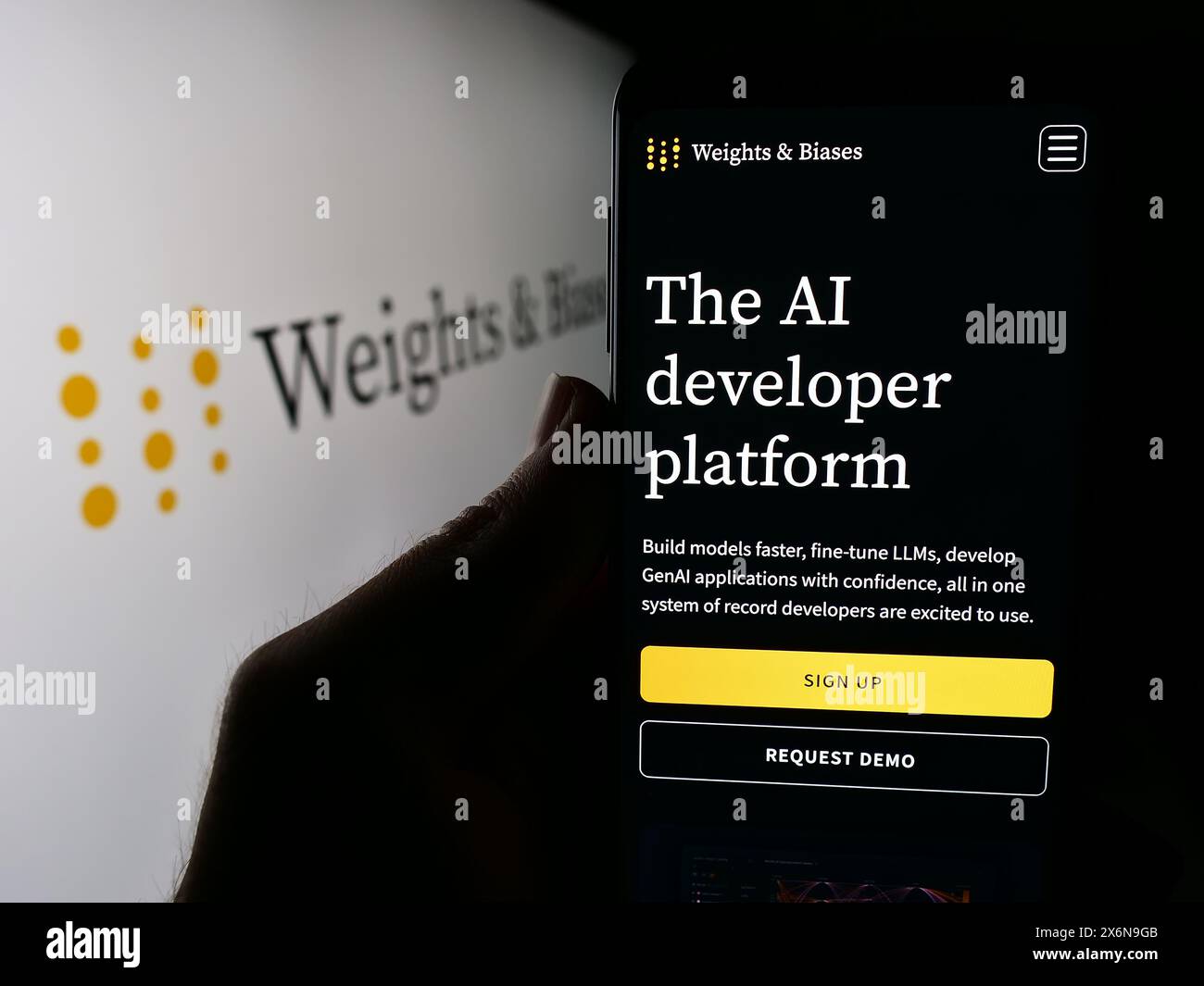 Personne tenant un smartphone avec la page Web de la société d'intelligence artificielle américaine poids et biais Inc avec logo. Concentrez-vous sur le centre de l'écran du téléphone. Banque D'Images