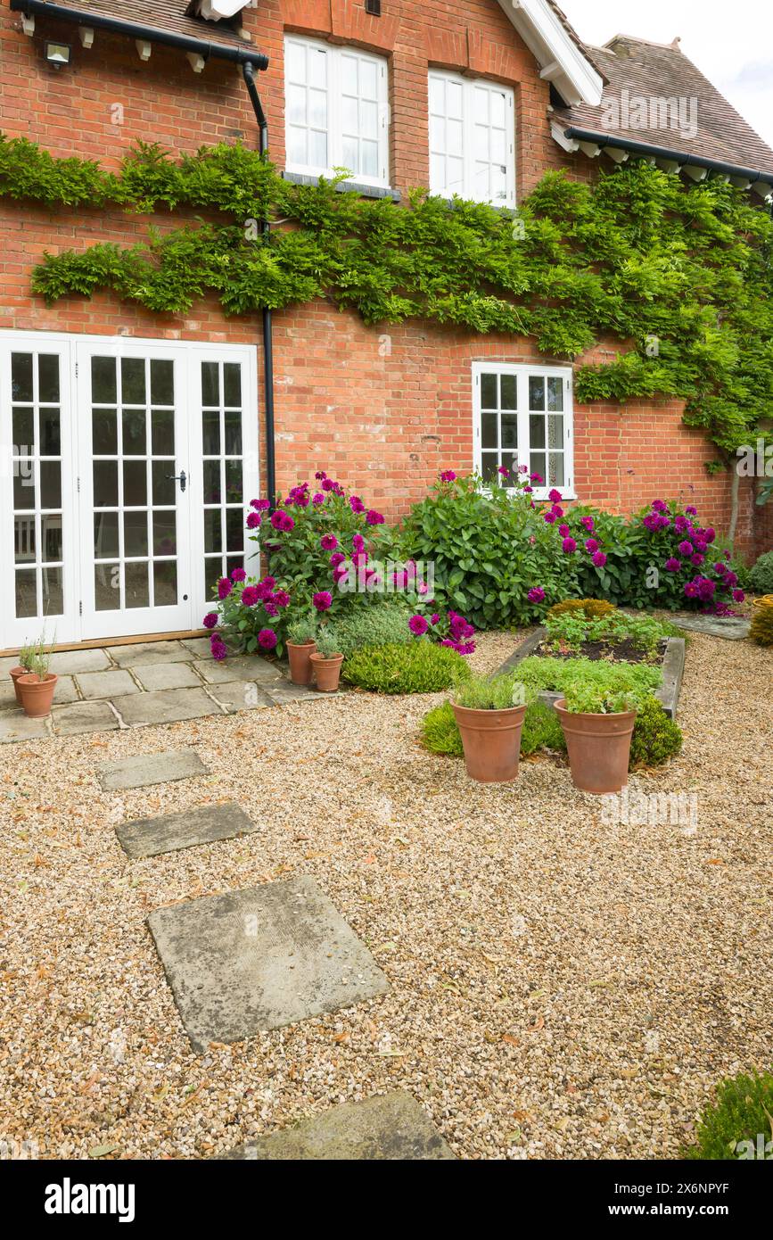 Maison britannique et jardin avec patio et portes françaises. Chalet ou jardin de cour (arrière-cour) avec gravier et pavage de pierre York Banque D'Images