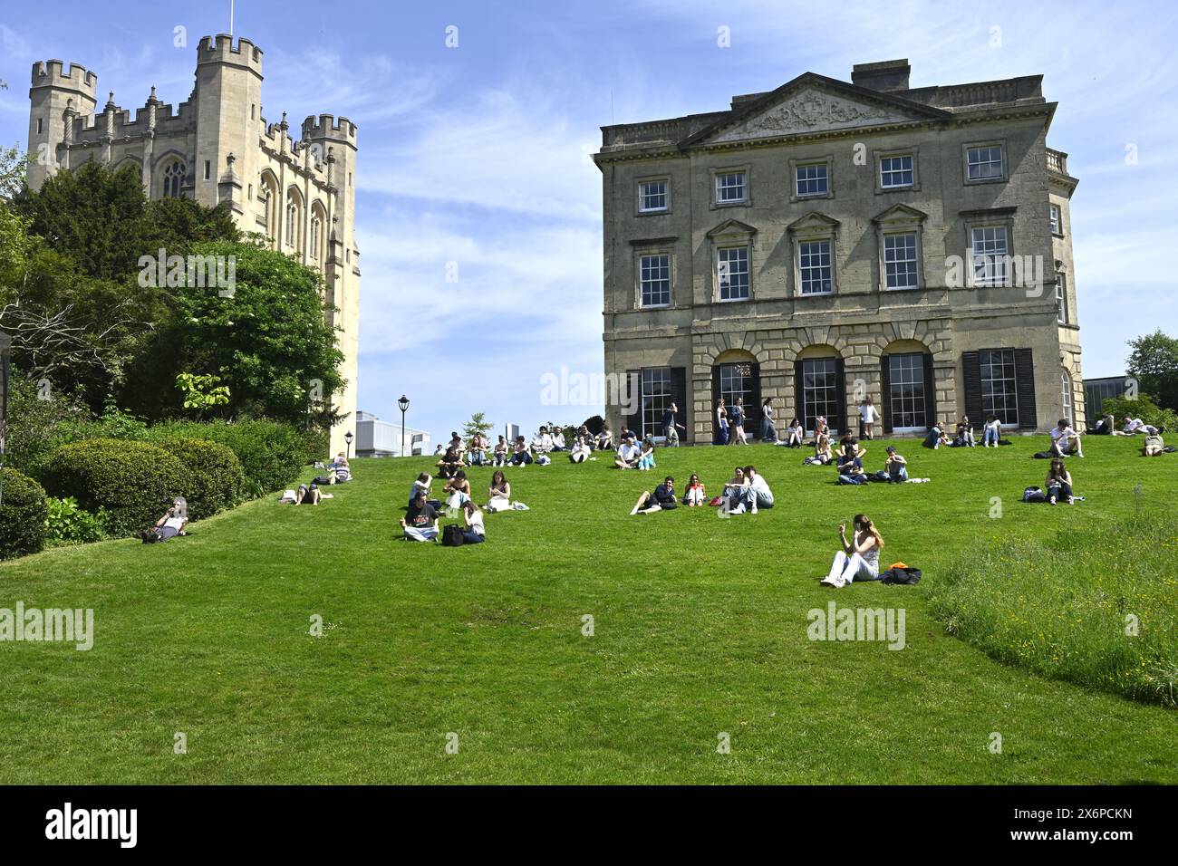 Étudiants appréciant le soleil sur la pelouse dans le jardin Royal Fort de l'Université de Bristol avec le bâtiment universitaire derrière Banque D'Images