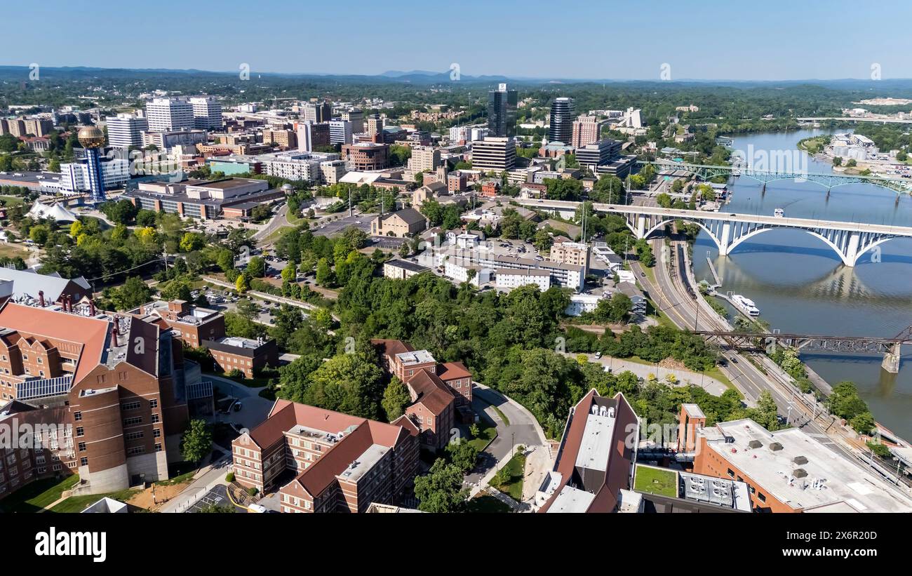 Une vue aérienne de Knoxville, Tennessee, révèle un paysage urbain dynamique avec un mélange de bâtiments historiques et modernes, la rivière Tennessee serpentant à travers le centre-ville, des parcs verdoyants et les lointaines Smoky Mountains encadrant l'horizon. Banque D'Images