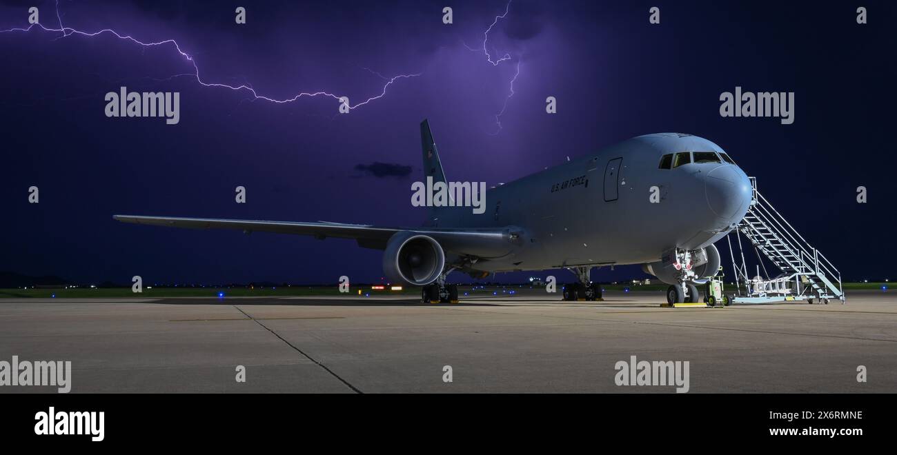 Un avion KC-46 Pegasus se trouve sur la ligne de vol à la base aérienne d'Altus, Oklahoma, le 30 avril 2024. La foudre a rempli le ciel au-dessus d'Altus et a créé un Banque D'Images