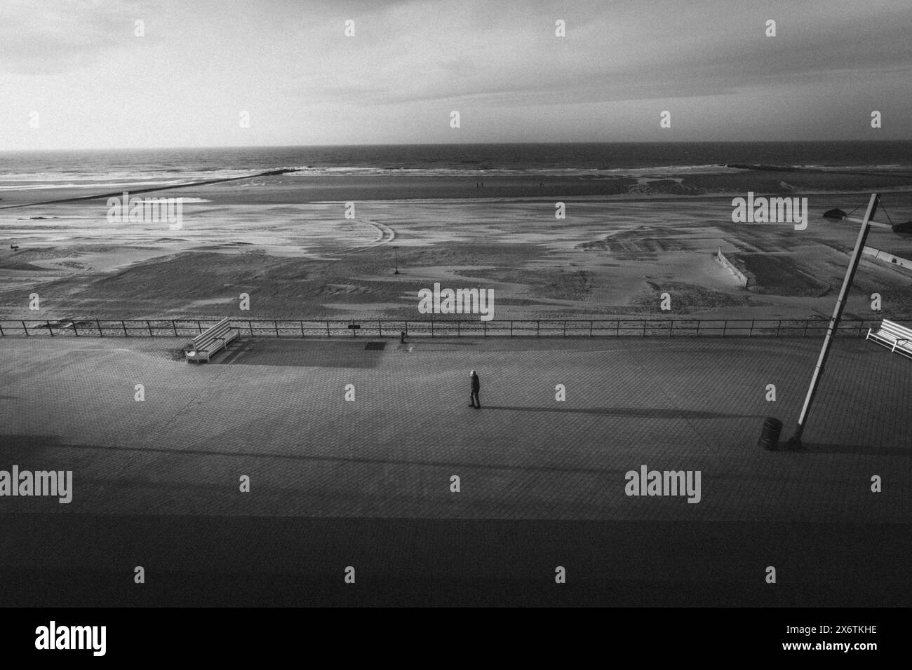 Les gens sur une promenade de plage vide avec vue sur la mer des Wadden. Middelkerke, Belgique Banque D'Images