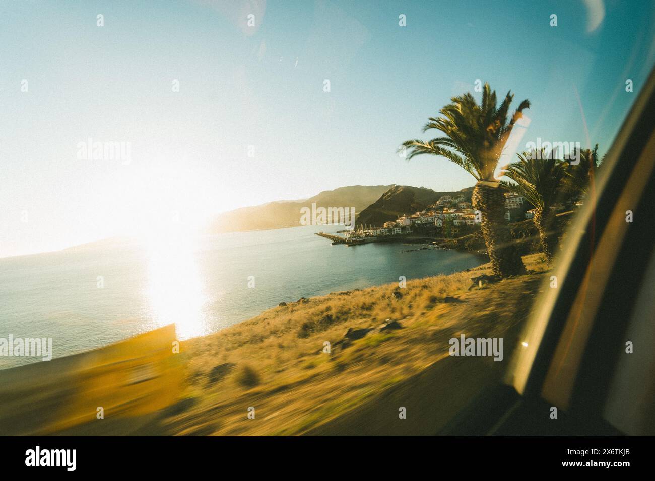 Vue d'une voiture en mouvement sur une plage ensoleillée avec des palmiers. Madère Portugal Banque D'Images