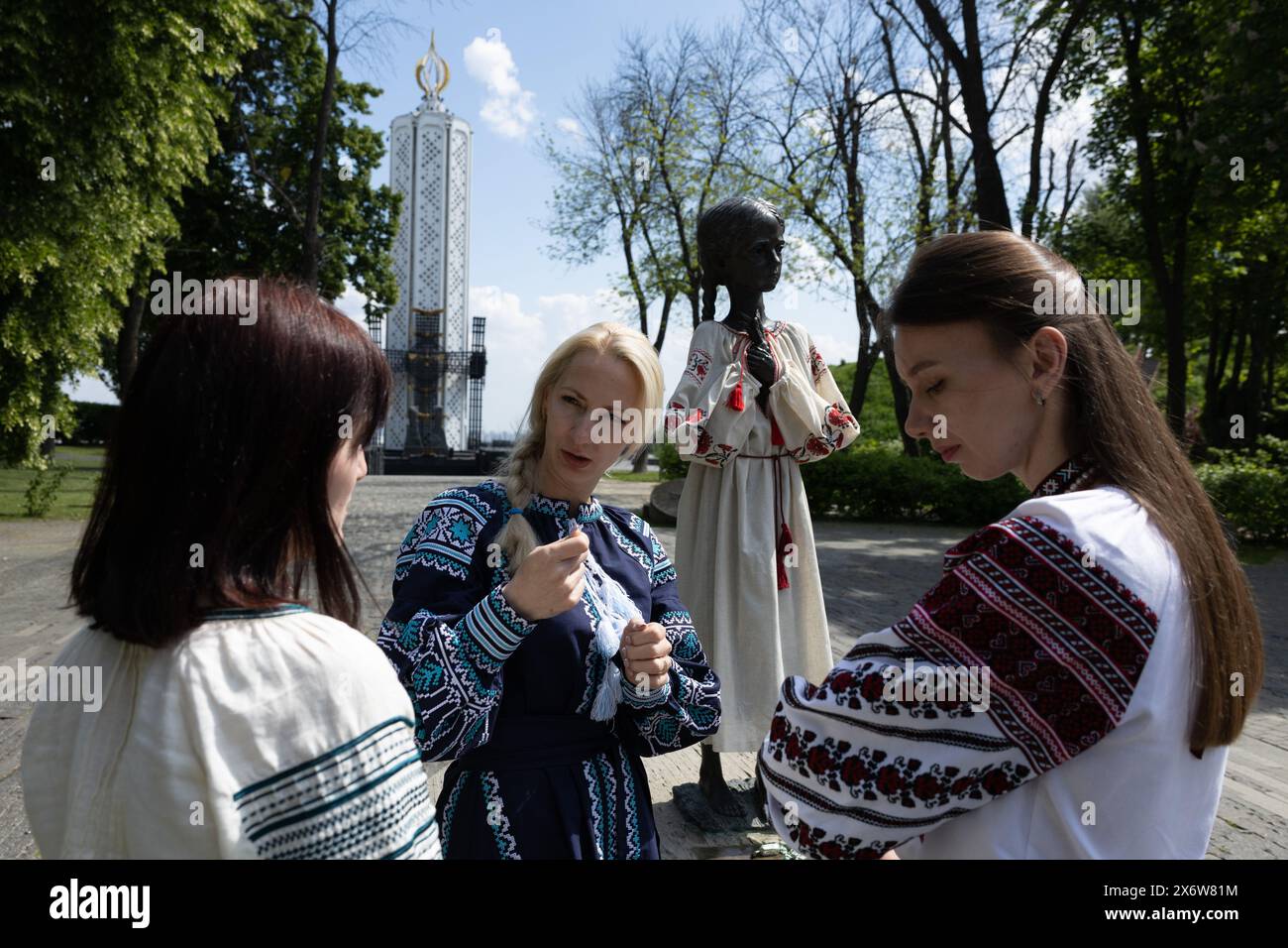 Kiev, Ukraine. 16 mai 2024. Des femmes vêtues de vyshyvankas (un vêtement traditionnel slave qui contient des éléments de broderie ethnique ukrainienne) parlent près du monument de la « mémoire amère de l'enfance » qui symbolise les victimes de l'Holodomor (famine) vêtues des mêmes vêtements à l'occasion de la Journée Vyshyvanka à Kiev. (Crédit image : © Oleksii Chumachenko/SOPA images via ZUMA Press Wire) USAGE ÉDITORIAL SEULEMENT! Non destiné à UN USAGE commercial ! Banque D'Images