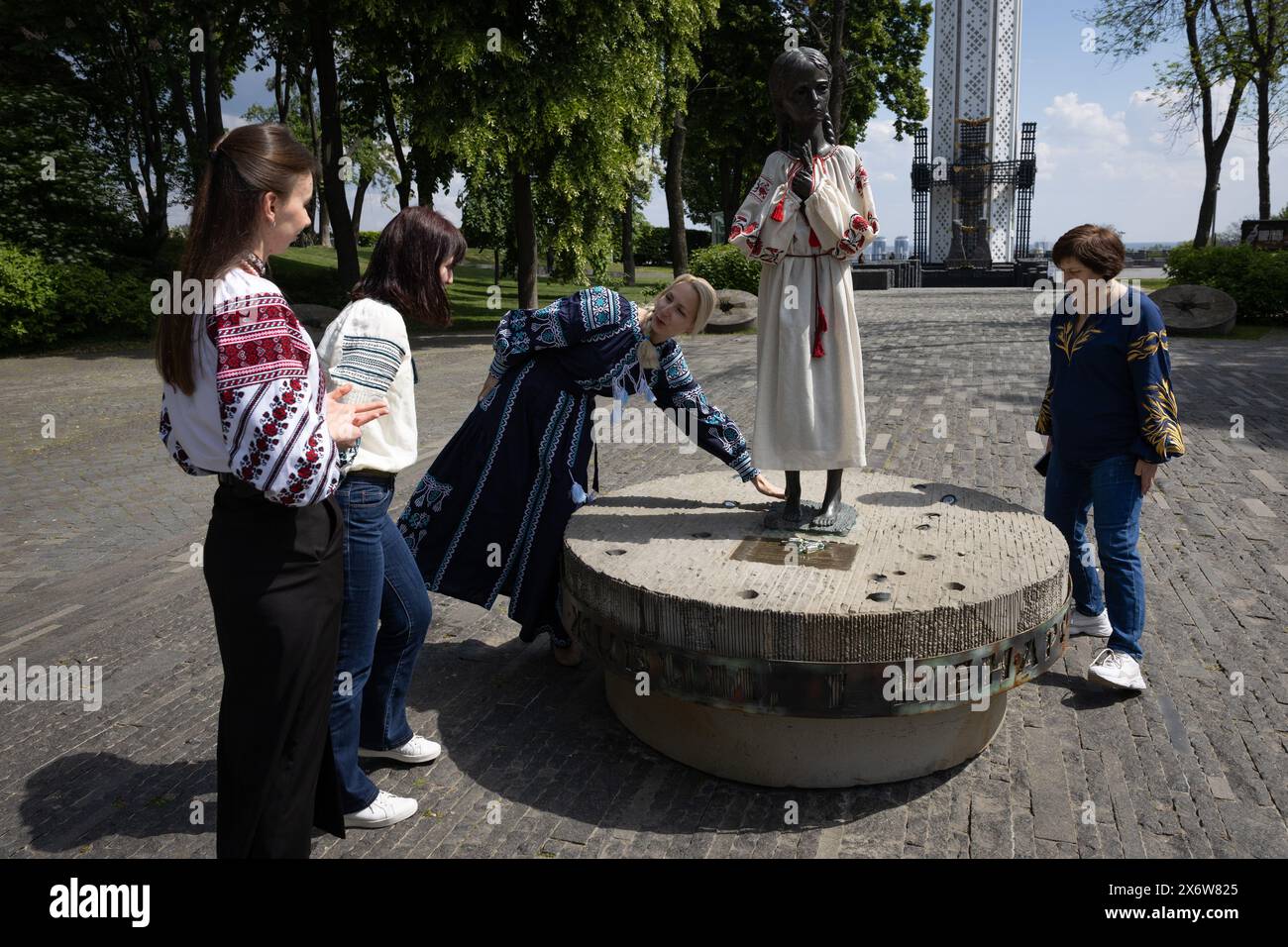 Kiev, Ukraine. 16 mai 2024. Les femmes vêtues de vyshyvankas (un vêtement traditionnel slave qui contient des éléments de broderie ethnique ukrainienne) regardent le monument «mémoire amère de l'enfance» qui symbolise les victimes de l'Holodomor (famine) vêtues des mêmes vêtements à l'occasion de la Journée de la Vyshyvanka à Kiev. (Crédit image : © Oleksii Chumachenko/SOPA images via ZUMA Press Wire) USAGE ÉDITORIAL SEULEMENT! Non destiné à UN USAGE commercial ! Banque D'Images