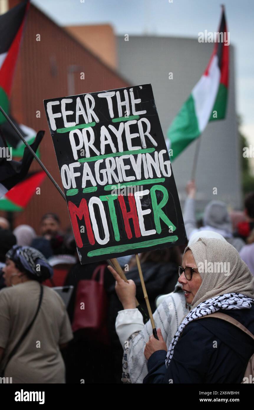 Manchester, Greater Manchester, Royaume-Uni. 15 mai 2024. Un manifestant porte une pancarte disant˜craignez la prière d'une mère en deuil' alors que la marche traverse la ville. Les manifestants descendent dans les rues de Manchester pour commémorer le 76e anniversaire de la Nakba (la catastrophe) lorsqu’en 1948, plus de 700 000 Palestiniens ont fui ou ont été expulsés de leurs maisons et de leurs terres par les paramilitaires et l’État israélien. Cette population et ses décents vivent en exil et promettent de revenir un jour. Ils terminent le rassemblement à l'Université de Manchester où les étudiants et leurs partisans ont mis u Banque D'Images