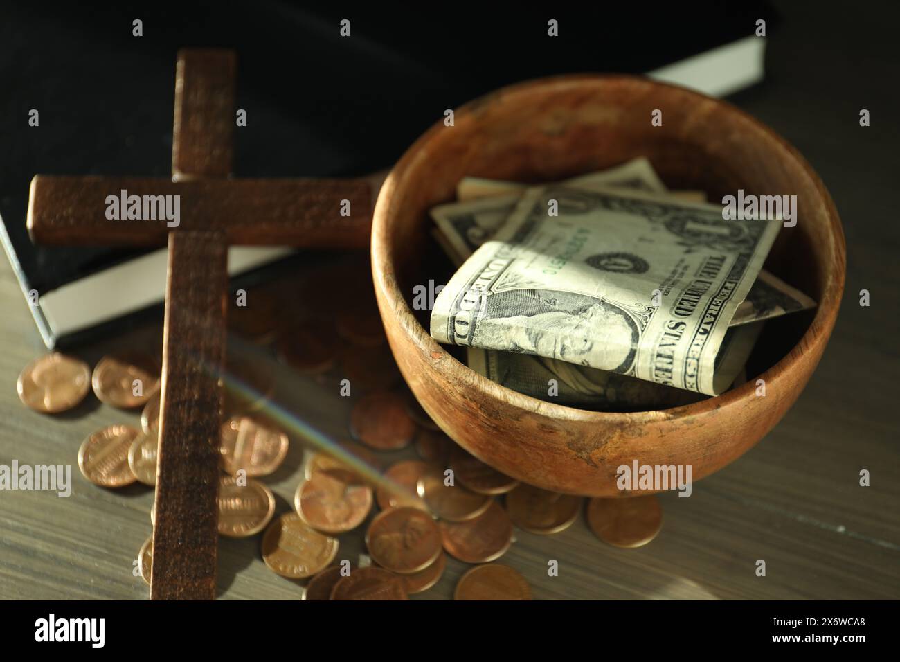 Donnez et donnez concept. Bol avec pièces de monnaie, billets de banque dollar, croix et Bible sur table en bois Banque D'Images