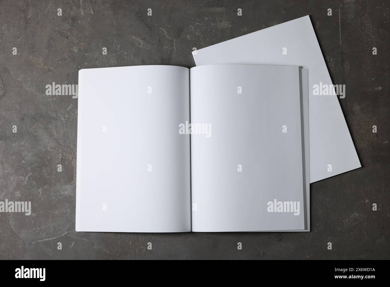 Ouvrez le carnet avec des feuilles de papier vierges sur fond texturé gris, vue de dessus. Maquette pour le design Banque D'Images
