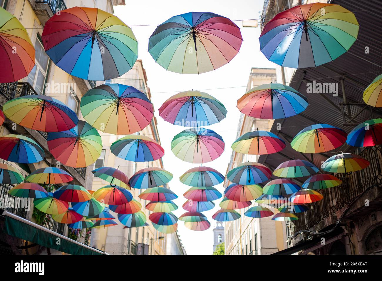 Des parapluies colorés ornent la rue, créant un affichage vibrant contre le ciel bleu. De nombreux parasols arc-en-ciel contribuent aux décorations festives de rue, en particulier pendant le mois de la fierté. Banque D'Images