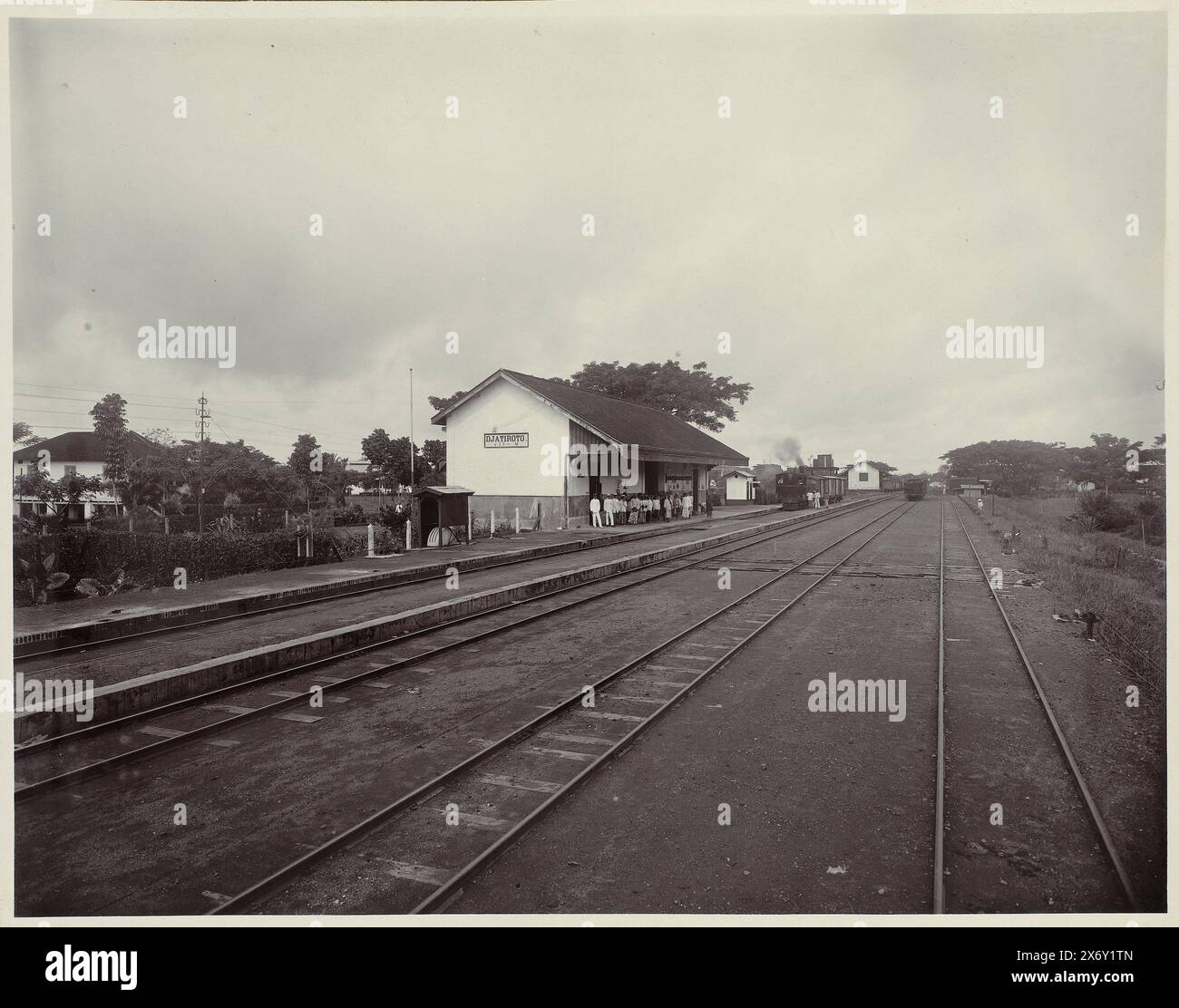 Station S. S. (titre sur l'objet), gare de Djatiroto avec quatre lignes de chemin de fer avec quelques wagons sur deux d'entre eux. Sur la droite le bâtiment de la gare avec des gens qui attendent sur le quai. Une partie de l'album photo présenté à F.J. Wirix par les employés de la société Djatiroto Sugar Company en 1917., photographie, Atelier Kurkdjian, Jatiroto, 1917, support photographique, hauteur, 297 mm × largeur, 376 mm Banque D'Images