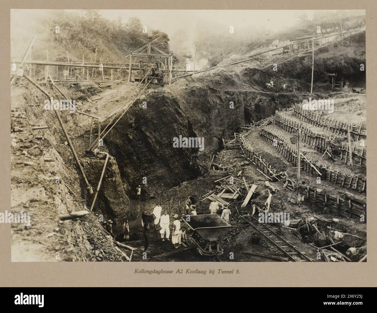 Kollong exploitation à ciel ouvert A2 veine de charbon au tunnel 8 (titre sur l'objet), exploitation du charbon dans une mine à ciel ouvert (exploitation à ciel ouvert). Vue de la veine de charbon exposée avec des ouvriers près d'un chariot basculant. Une partie de l'album photo à feuilles mobiles présenté par le personnel des mines de charbon Boekit-Asam à Sumatra à l'ingénieur-directeur sortant H. Tromp le 7 janvier 1922., photographie, anonyme, Boekit-Asam, 1921 - 1922, support photographique, tirage argenté gélatineux, hauteur, 278 mm × largeur, 392 mm Banque D'Images