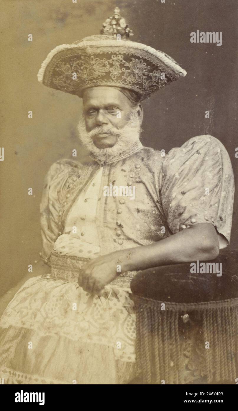 Portrait d'un homme barbu portant une veste avec des épaulettes et une grande coiffe décorée, roi de Rauden (?) (titre sur objet), photographie, anonyme, (éventuellement), anonyme, (mentionné sur l'objet), pays-Bas, Colombo, c. 1890 - c. 1910, papier, impression gélatineuse argentée, hauteur, 96 mm × largeur, 141 mm, hauteur, 570 mm × largeur, 463 mm Banque D'Images