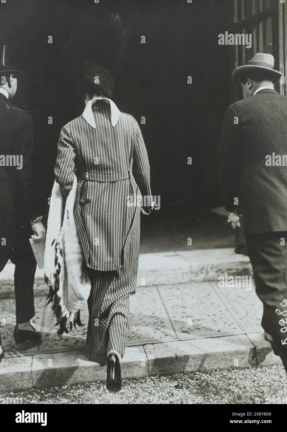 Deux hommes et une femme dans la rue, Paris, à gauche un homme en costume de matin avec un chapeau haut de gamme. À côté de lui se trouve une femme en costume rayé avec une longue jupe et un châle sur son bras. A droite un homme portant un chapeau., photographie, Louis Meurisse, (attribué à), Paris, c. 1913 - c. 1914, papier baryta, impression gélatineuse argentée, hauteur, 178 mm × largeur, 130 mm Banque D'Images