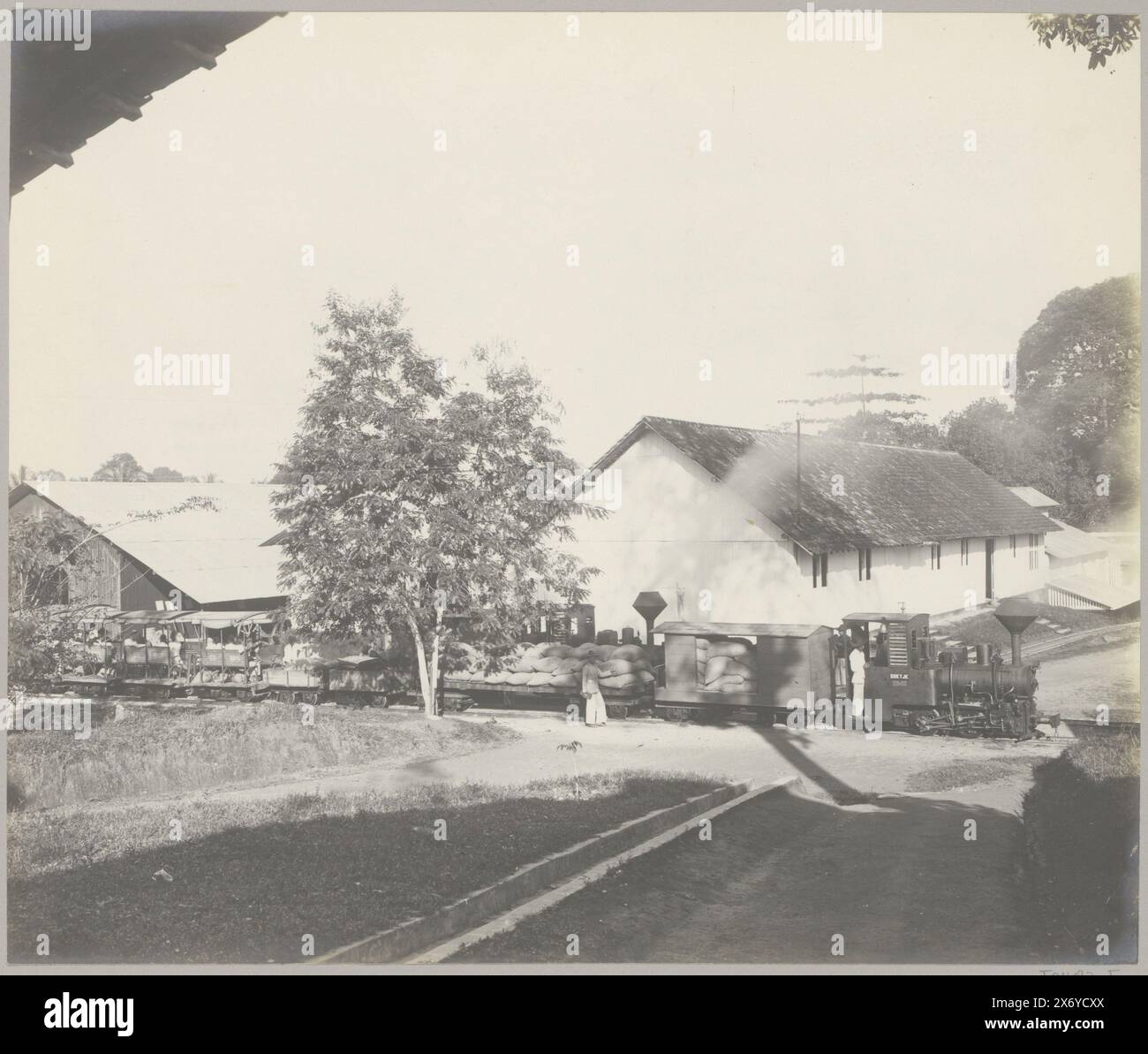 Train à vapeur dans une entreprise d'étain à Belinyu, Blinjoe. Tramway à vapeur devant les ateliers, transportant du riz et des coolies (titre sur l'objet), partie de l'album photo sur l'extraction de l'étain sur Bangka., photographie, anonyme, Belinyu, c. 1900 - c. 1920, support photographique, tirage argenté gélatineux, hauteur, 240 mm × largeur, 284 mm Banque D'Images