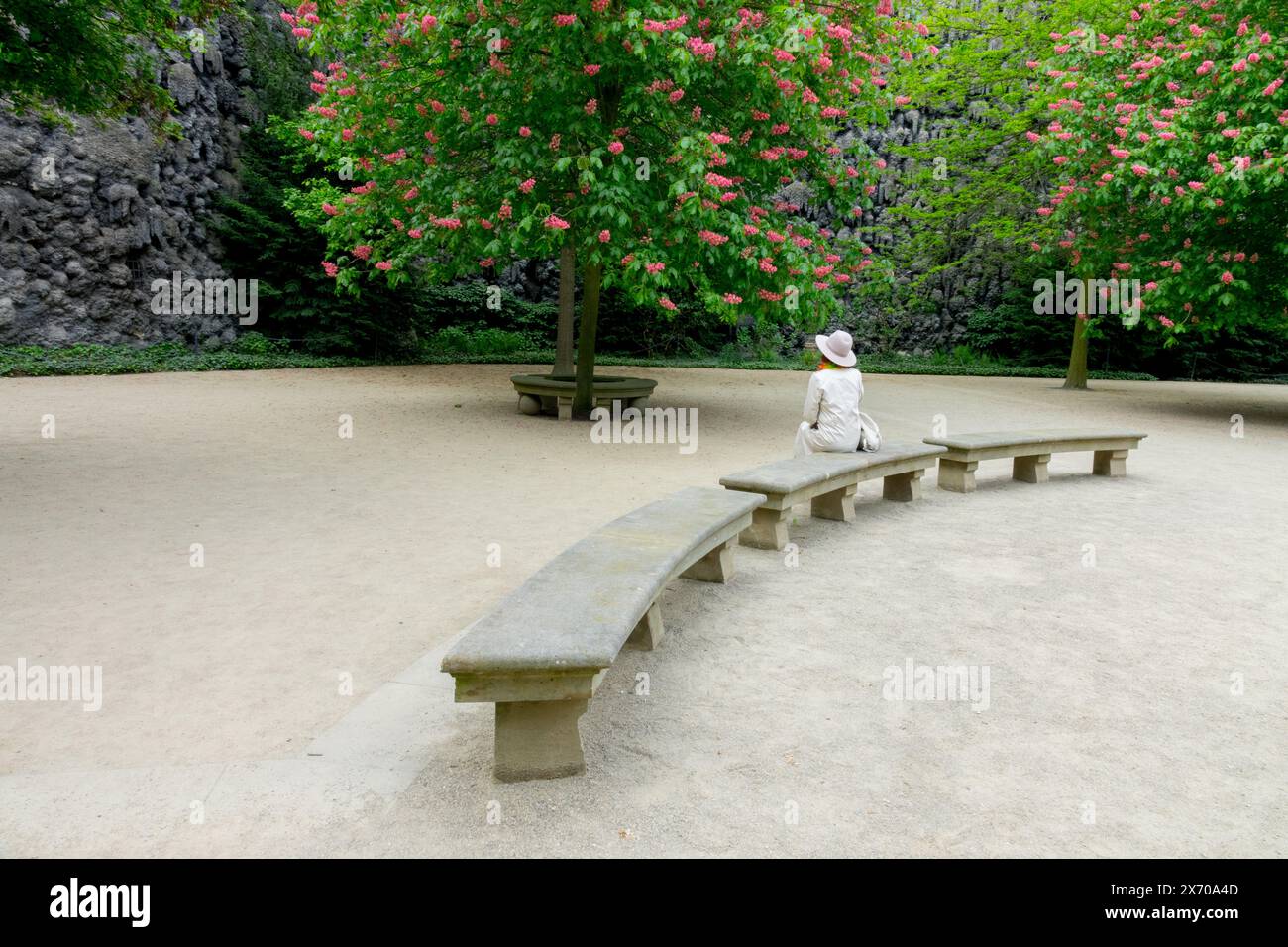Femme assise sur un banc de pierre dans Wallenstein Park Garden Prague Mala Strana Banque D'Images