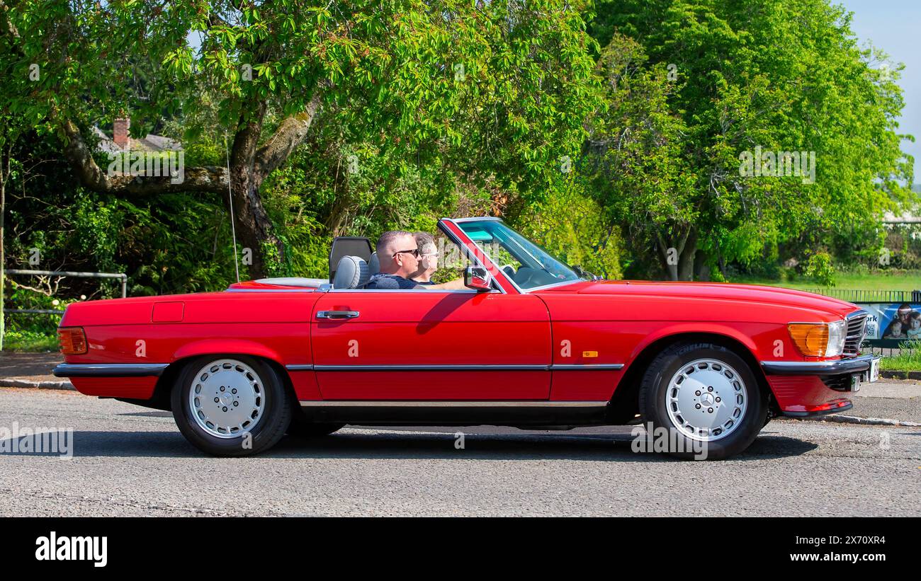 Stoke Goldington, Royaume-Uni - 11 mai 2024 : 1987 rouge Mercedes Benz 300 sl voiture classique conduite sur une route britannique Banque D'Images