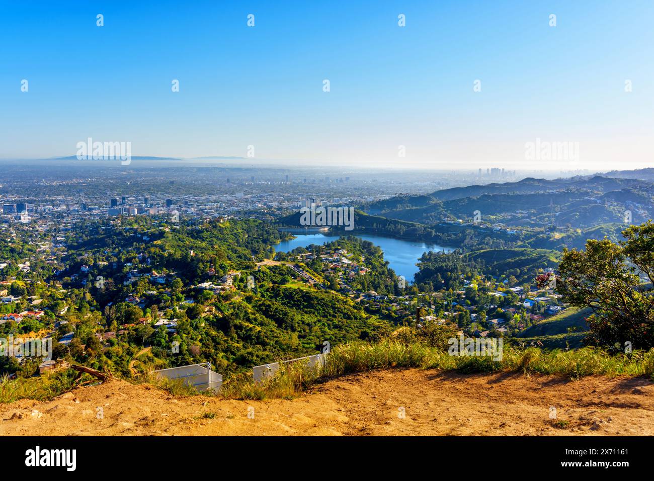 Vue aérienne du réservoir Hollywood et de la ville tentaculaire de Los Angeles capturée depuis un point de vue au sommet d'une colline par une journée ensoleillée. Banque D'Images