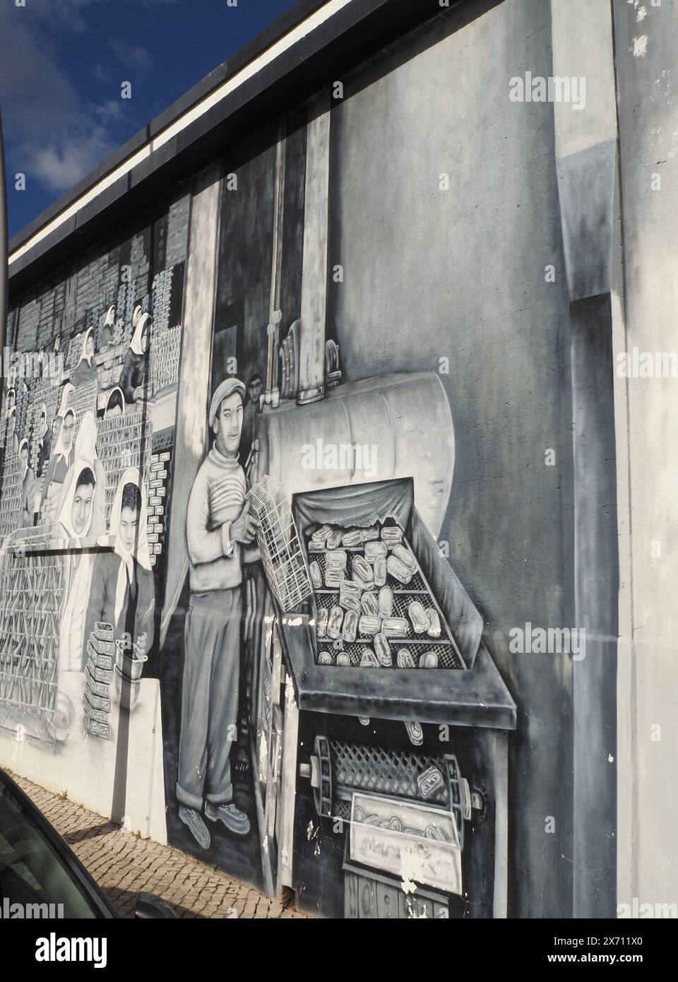 Peintures murales en noir et blanc sur et près de la Rua Manuel Tomé Viegas Vaz, Olhão, Portugal représentant la célébration du patrimoine de l'industrie de la pêche et de la conserve de la ville Banque D'Images