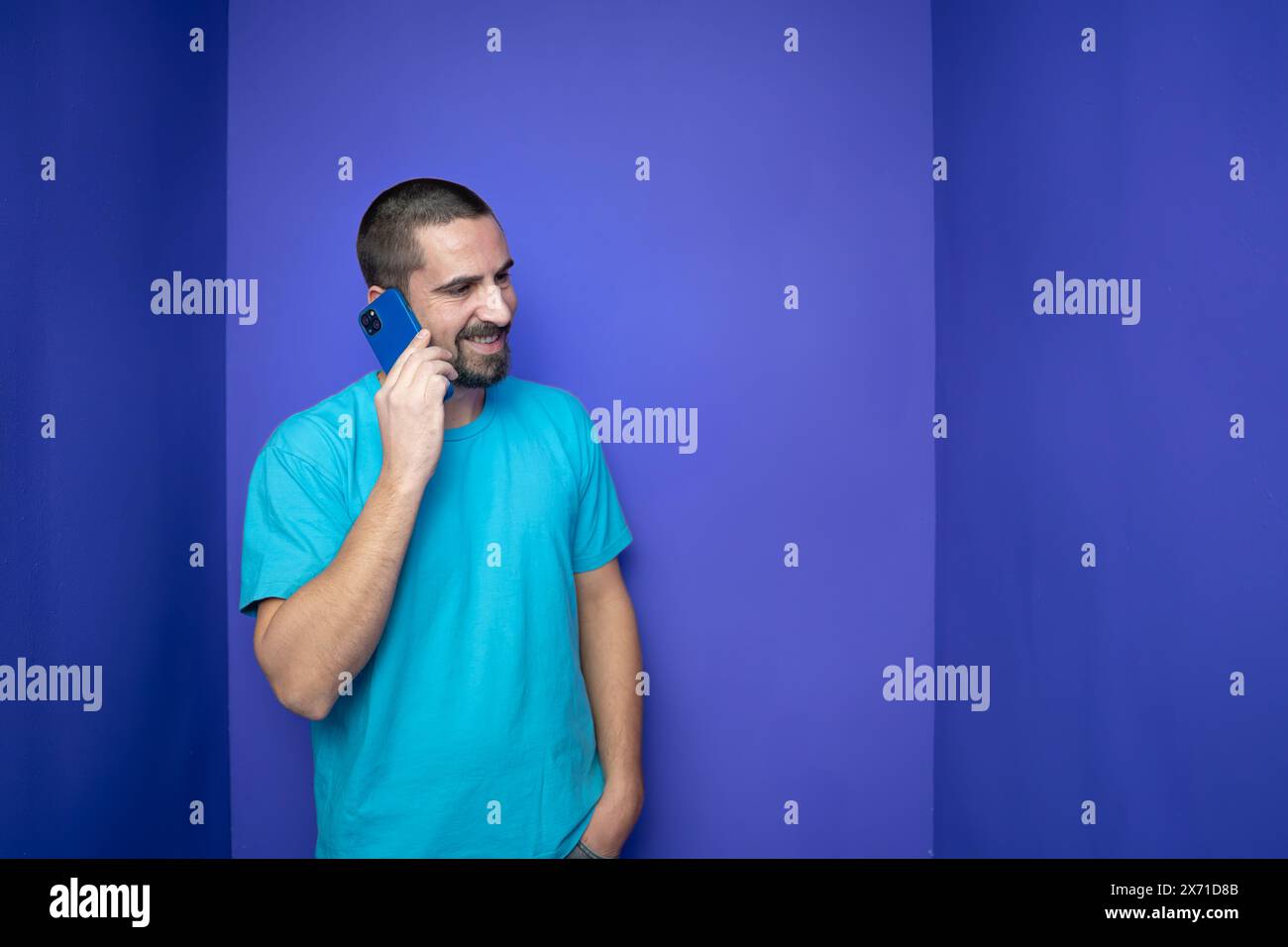 Heureux jeune homme parlant avec un téléphone portable sur fond de couleur Banque D'Images