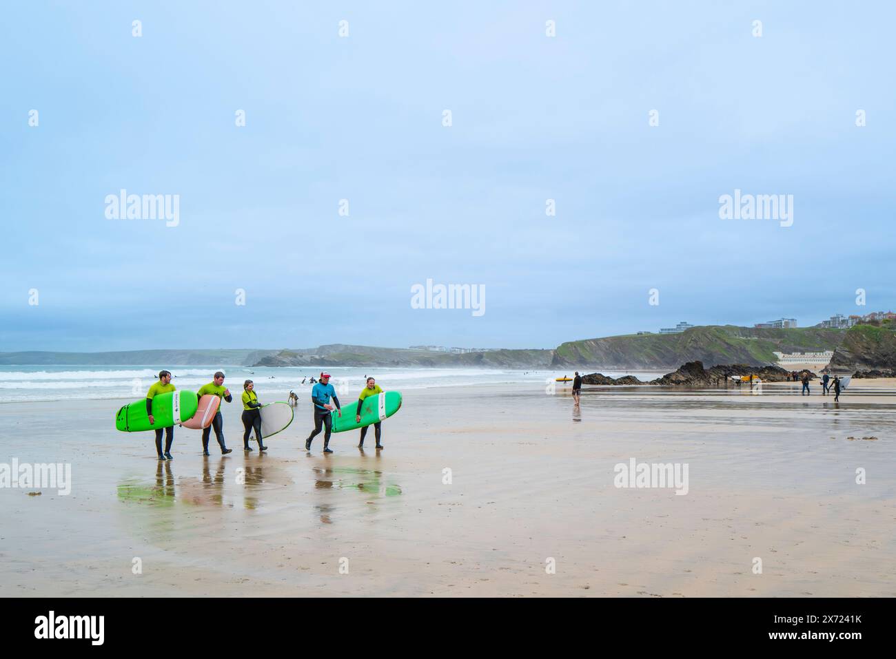 Un instructeur de surf de l'Escape Surf School marchant avec un groupe de surfeurs débutants sur la plage de Towan à Newquay en Cornouailles au Royaume-Uni. Banque D'Images