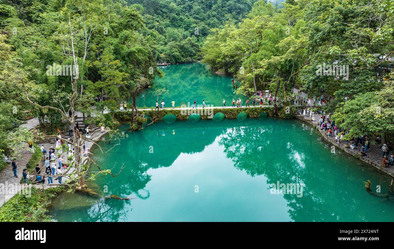 Libo. 16 mai 2024. Une photo de drone aérien prise le 16 mai 2024 montre des touristes visitant la zone pittoresque de Xiaoqikong dans le comté de Libo, dans la province du Guizhou, au sud-ouest de la Chine. Situé sur le flanc de montagne escarpé de Guizhou, Libo County a des vues spectaculaires en abondance et a connu un boom dans le tourisme ces dernières années. Crédit : Tao Liang/Xinhua/Alamy Live News Banque D'Images