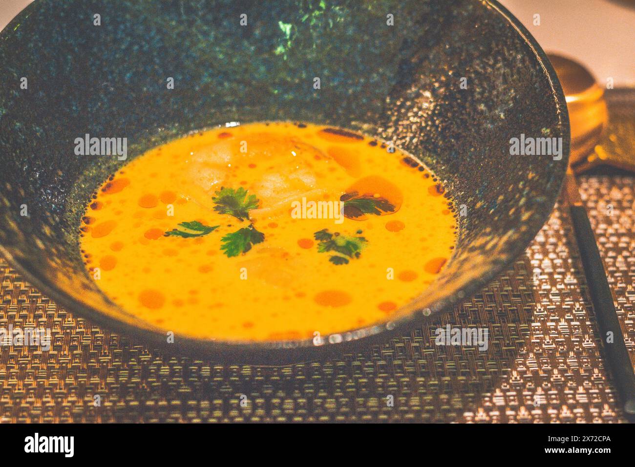 Soupe sri-lankaise aux crevettes au curry et aux pétoncles safran, assortiment de curry traditionnel en poudre, piment vert, gingembre, coriandre et citron vert Banque D'Images