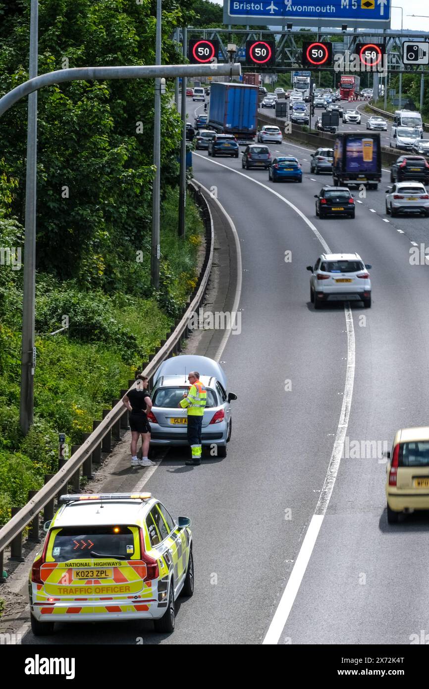 Bristol, Royaume-Uni. 17 mai 2024. Une voiture en panne sur la voie intérieure de l'autoroute gérée ajoute aux problèmes des conducteurs sur une autoroute déjà encombrée. Sans une épaule dure, le conducteur a dû appeler à l'aide, puis s'asseoir sur un tronçon très occupé de l'autoroute. L'escapade ensoleillée du week-end avait déjà causé des embouteillages avec des panneaux Matrix limitant la vitesse à 40/50mph sur la M5 entre les jonctions 15/16 et 17 à Bristol. Highways England rapporte des vitesses dans les années 20, ce qui est normal un vendredi ensoleillé quand les gens se dirigent vers le sud vers Devon et Cornwall. Crédit : JMF News/Alamy Live News Banque D'Images