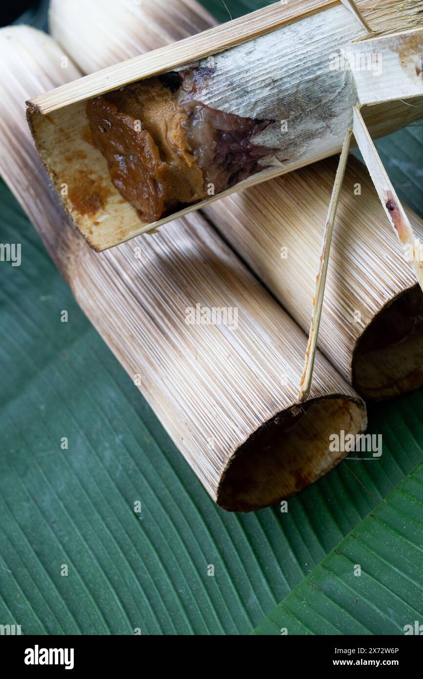 Joint de bambou grillé farci de riz gluant et de Custard sur feuille de banane Banque D'Images