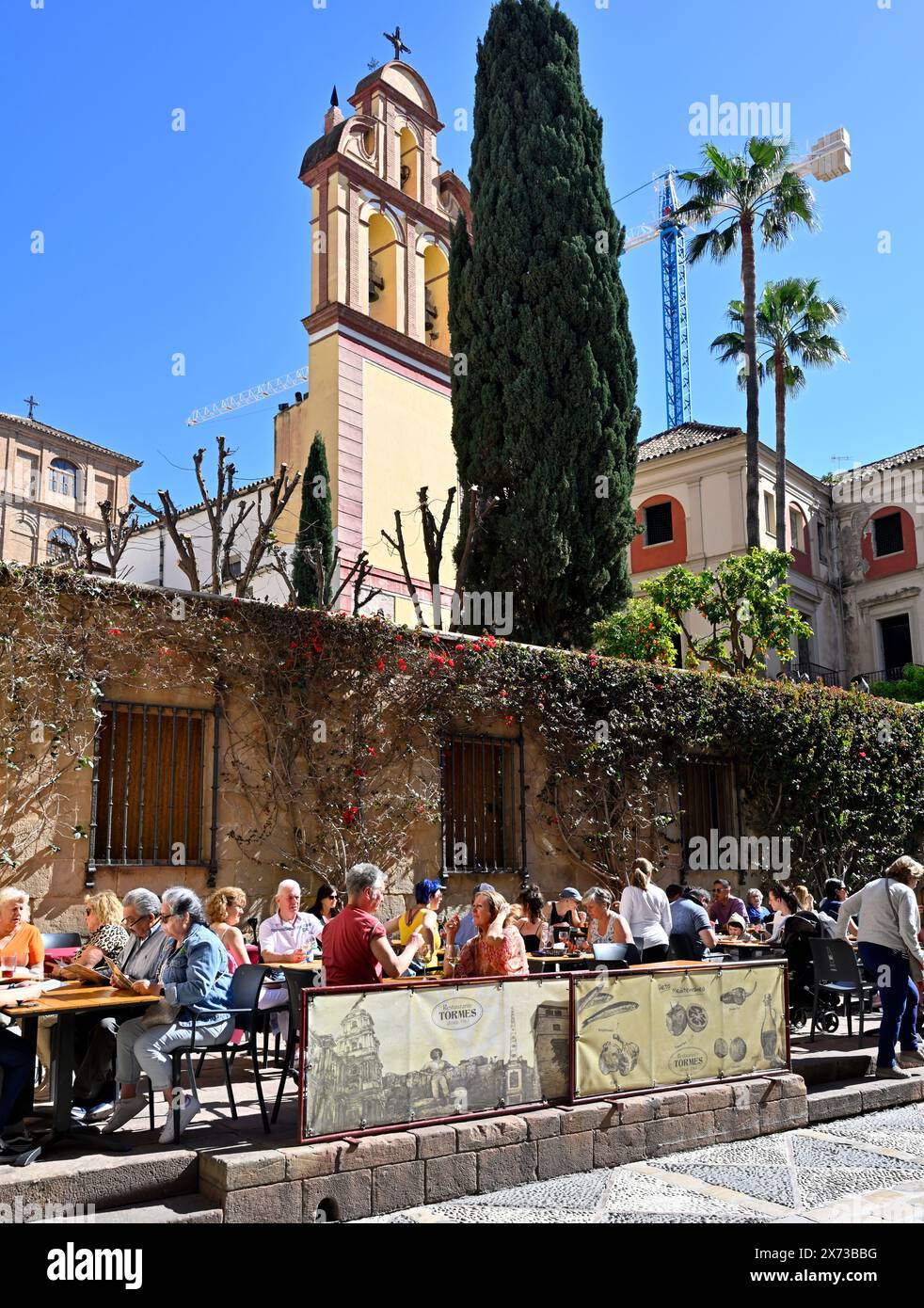 Manger sur le trottoir au Restaurante Tormes près du musée Picasso avec l'église des membres Augustine clocher derrière Banque D'Images