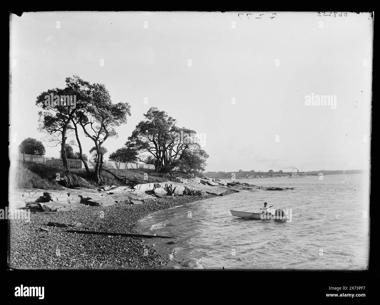 Homme en bateau avec piège à poissons près de la plage, titre conçu par cataloger., peut-être Adirondack Mountains, New York., 'G 277' sur négatif., Detroit Publishing Co. no. 068255., Gift ; State Historical Society of Colorado ; 1949, Beaches. , Bateaux. Banque D'Images