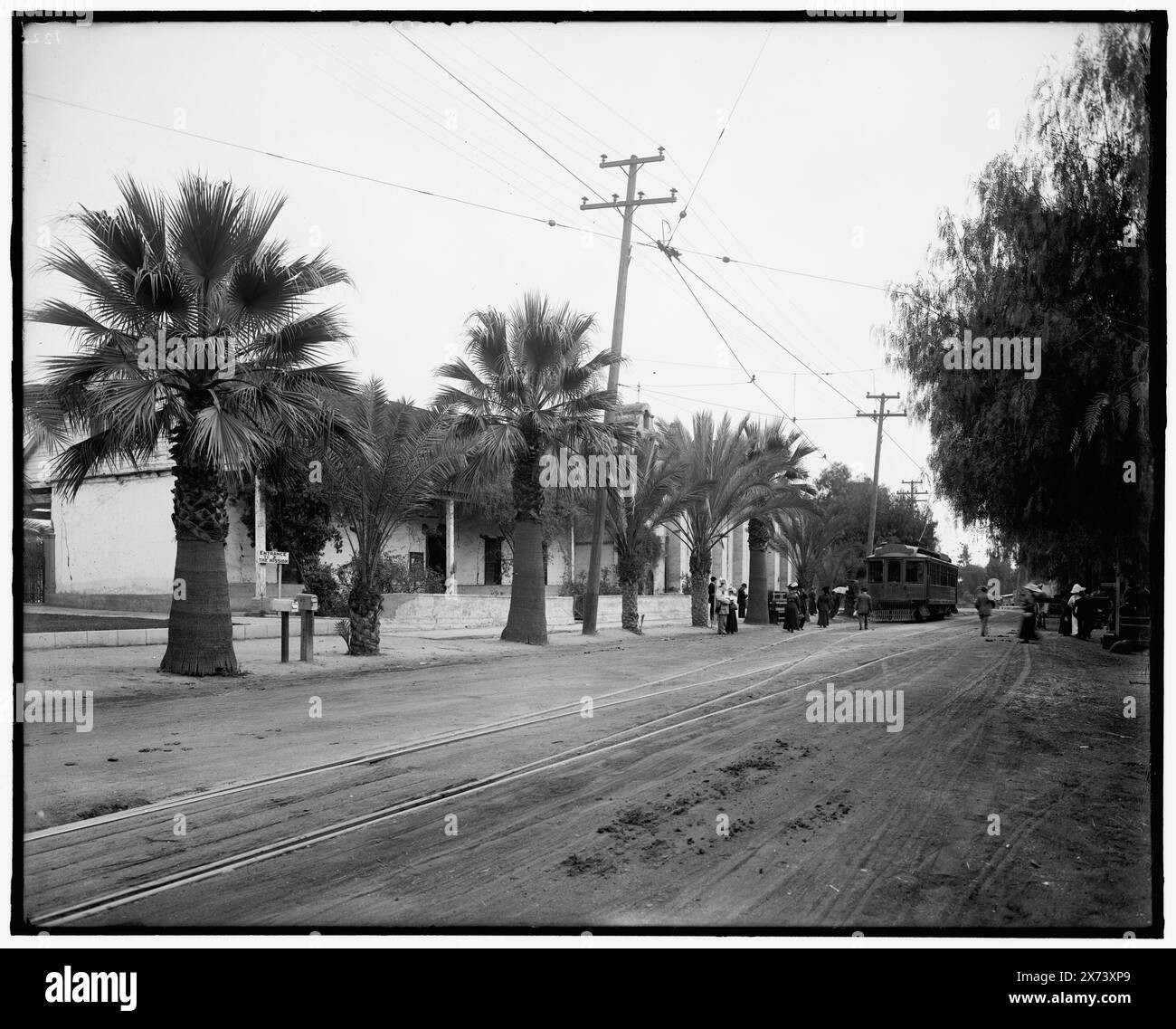 Mission et ancienne mission voyage en trolley, probablement en Californie, titre conçu par cataloger ; locale basée sur des négatifs avec des numéros similaires., 'entrée à la mission' et 'Old tenu [, .] Mis[sion]' sur le panneau à gauche., '122' sur le négatif., No Detroit Publishing Co. No., cadeau ; State Historical Society of Colorado ; 1949, Palms. , Chemins de fer de rue. , États-Unis, Californie. Banque D'Images