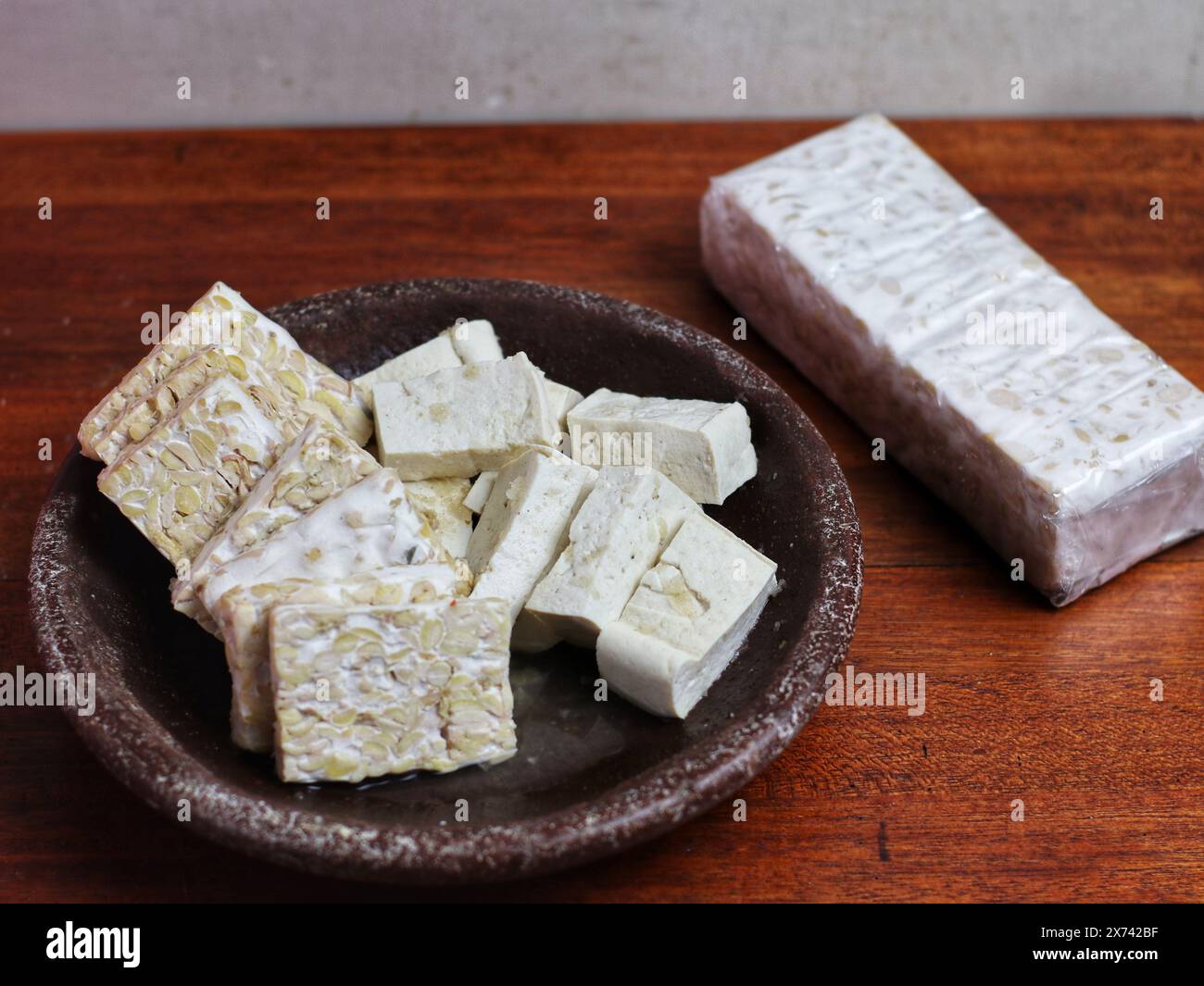 morceaux de tempeh dans un mortier sur une table en bois Banque D'Images