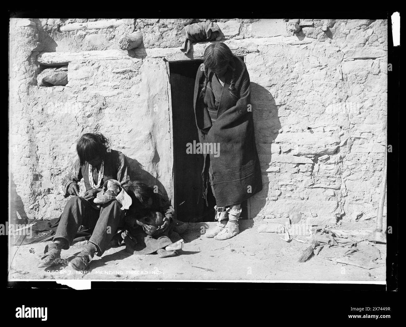 Hopi Mending Moccasins, Detroit Publishing Co. No. 04034wq!9., cadeau ; State Historical Society of Colorado ; 1949, Indiens Hopi. , Indiens d'Amérique du Nord, Arts et métiers. , Couture. , Cordonnerie. Banque D'Images