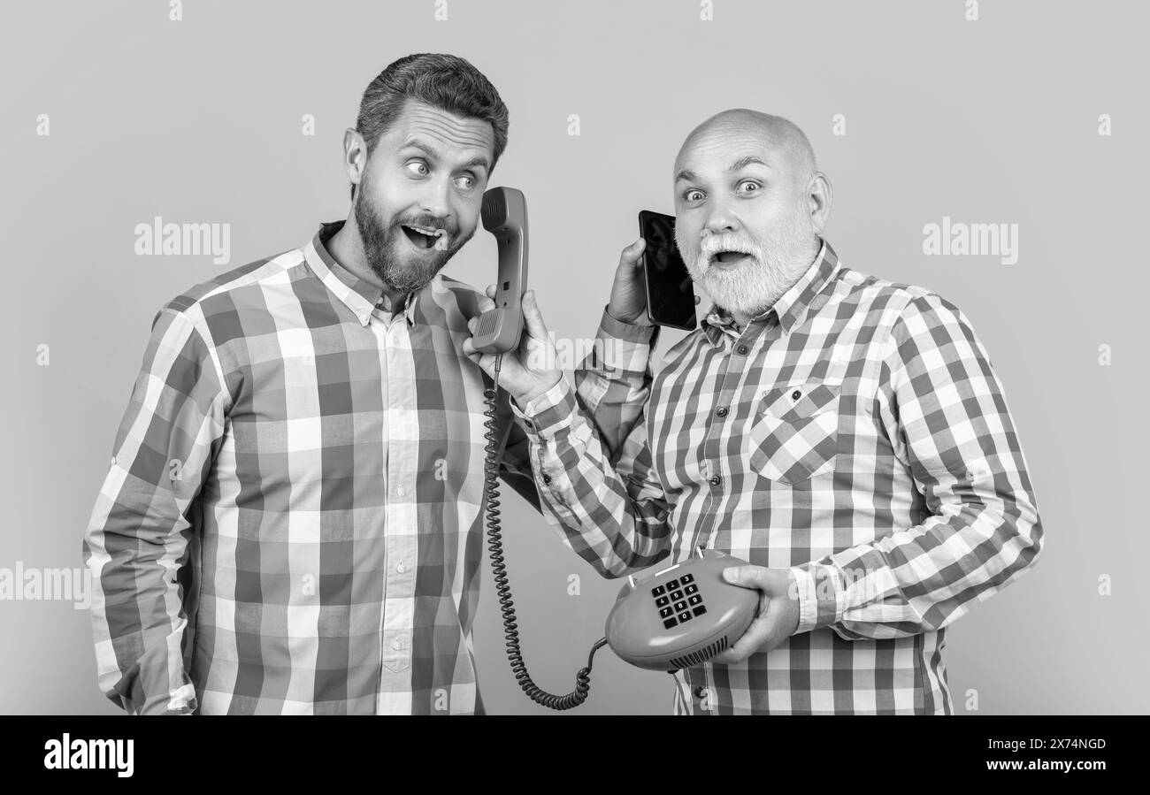 les hommes avec le contraste téléphonique appellent dans le studio jaune. les hommes avec le contraste téléphonique appellent sur le fond. Banque D'Images