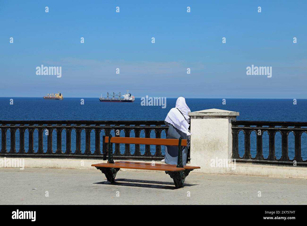 Femme sur le front de mer d'Alger regardant au-dessus de la Méditerranée Banque D'Images