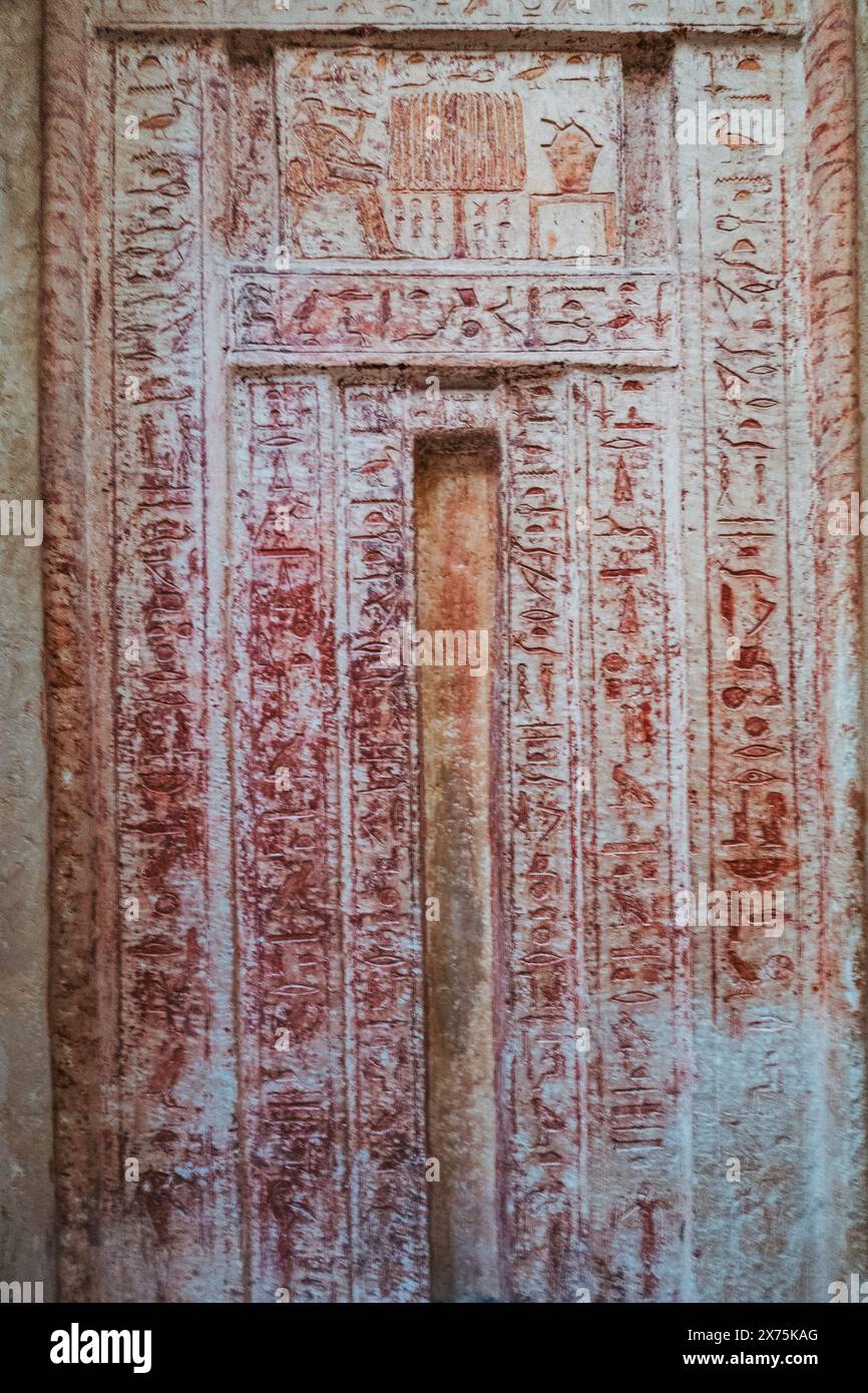 Fausse porte d’un tombeau mastaba de l’ancien Empire à Saqqara, sculptée et peinte avec des hiéroglyphes, servant de portail pour l’esprit du défunt à recevoir Banque D'Images
