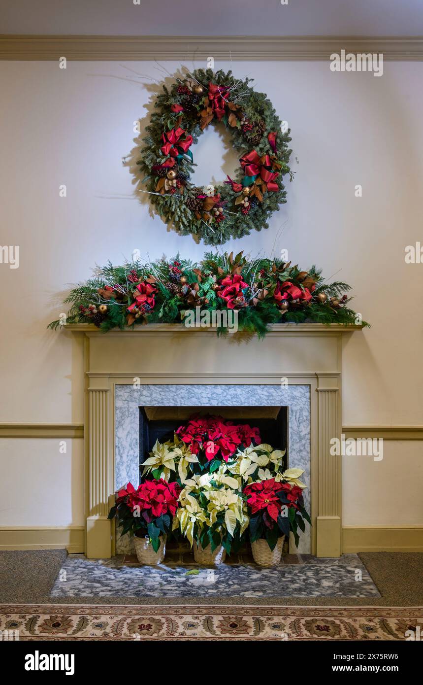 Cheminée avec couronne et plantes poinsettia Banque D'Images