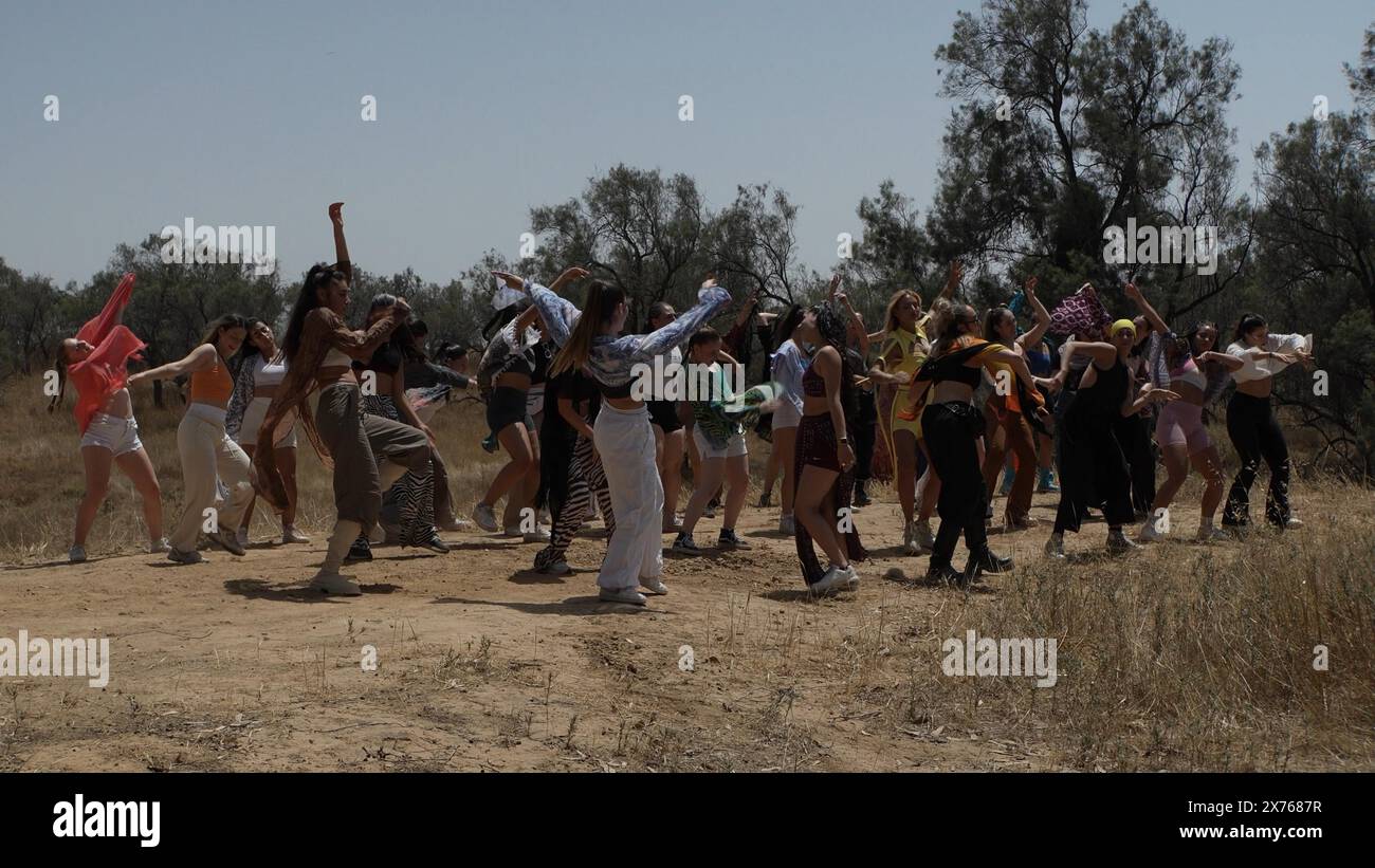 RE'IM, ISRAËL - 17 MAI : la chanteuse judéo-américaine Montana Tucker danse avec les membres du Dance Studio qui ont perdu quatre de ses membres au Nova Music Festival le 7 octobre sur le site du festival de musique Supernova qui a coûté la vie à 364 festivaliers israéliens et des dizaines enlevés par des militants du Hamas en mai 17, 2024 à Re'im, Israël. Banque D'Images