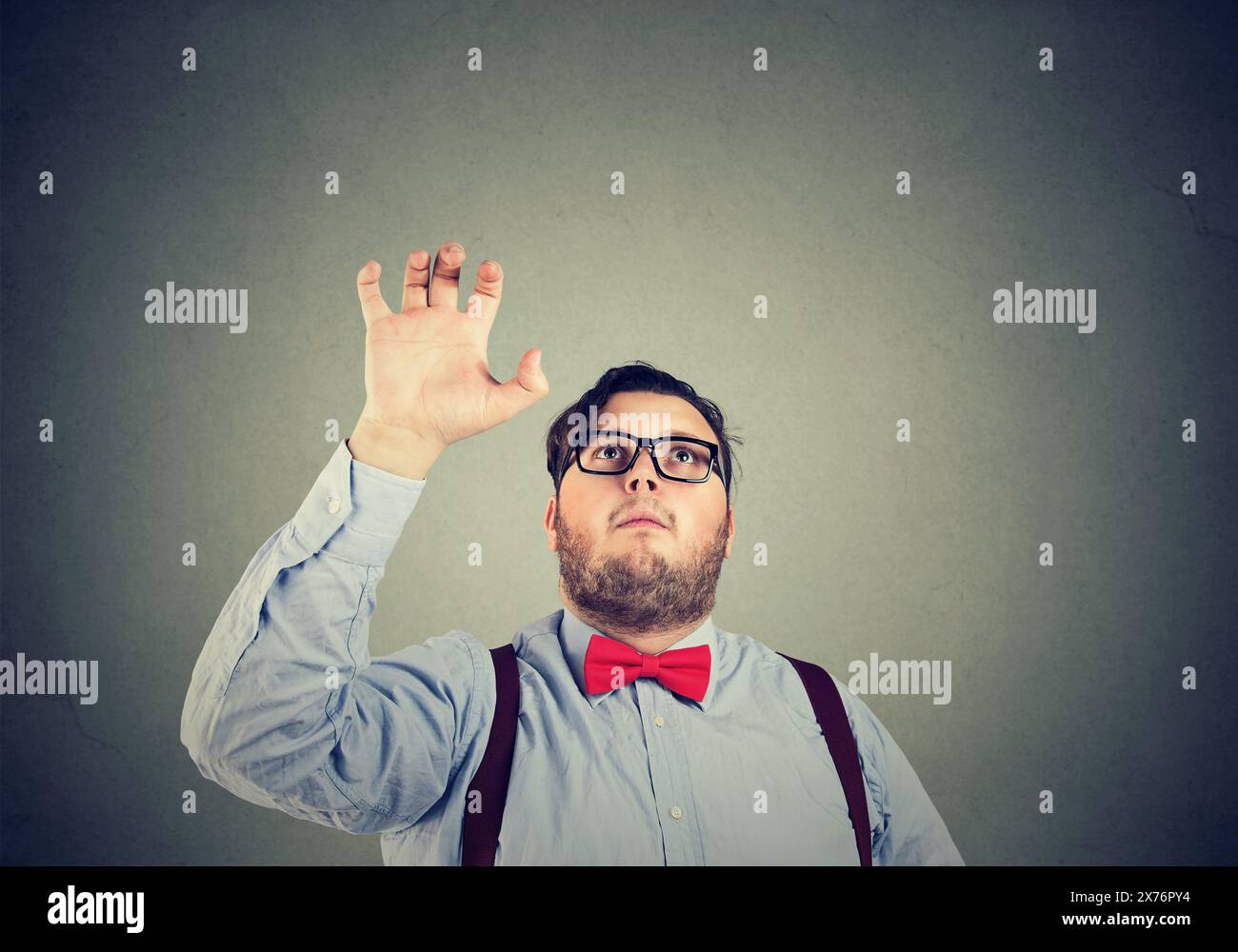 homme d'affaires avec une main levée essayant d'attraper quelque chose au-dessus Banque D'Images