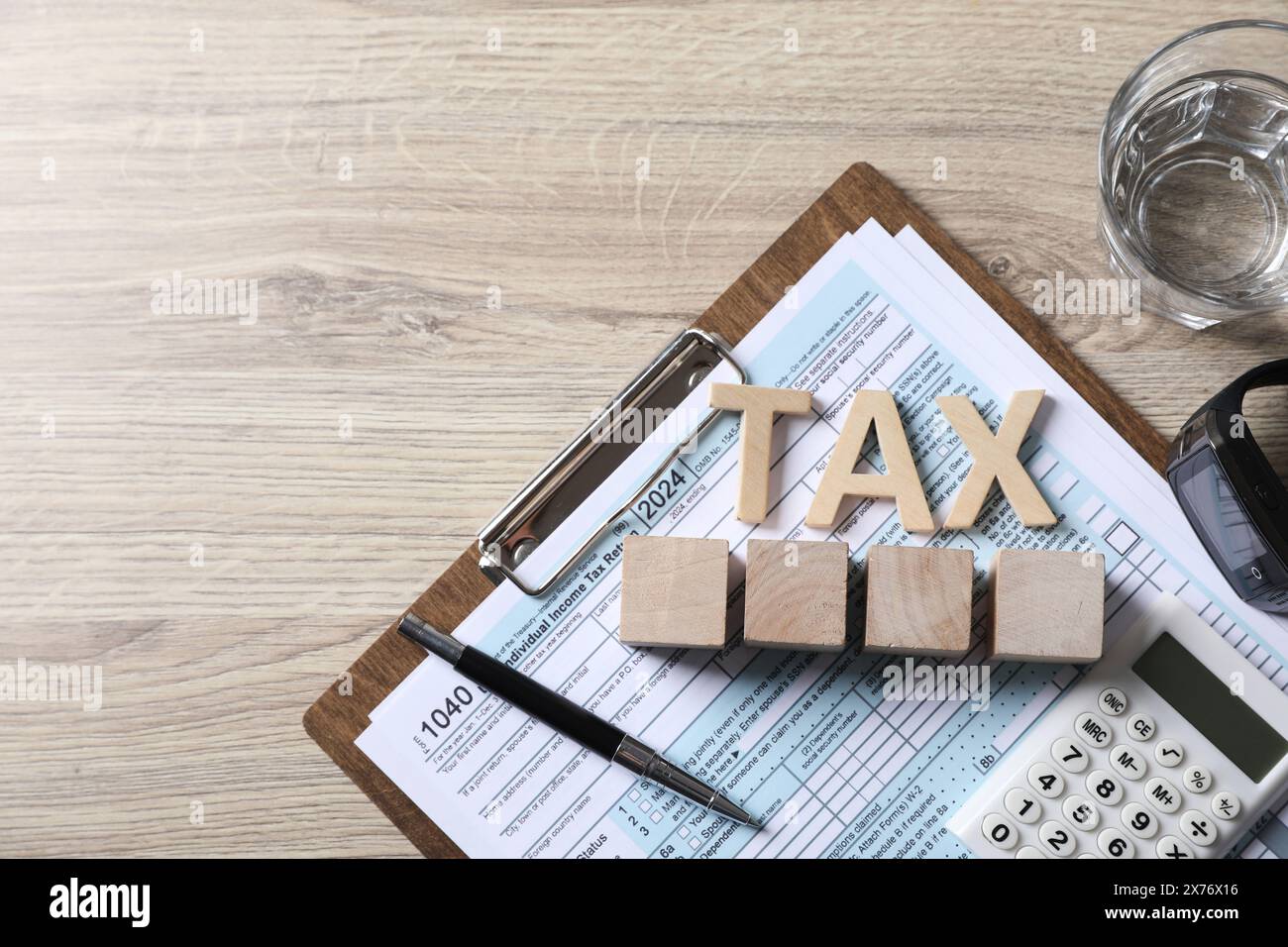 Word Tax, cubes, calculatrice, stylo et document sur table en bois, vue de dessus. Espace pour le texte Banque D'Images