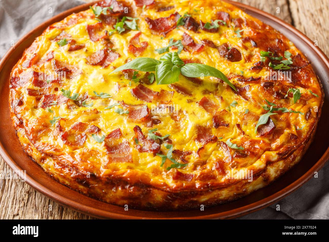 Savoureuse quiche sans croûte avec bacon, oeuf, poulet et fromage gros plan sur l'assiette sur la table en bois. Horizontal Banque D'Images