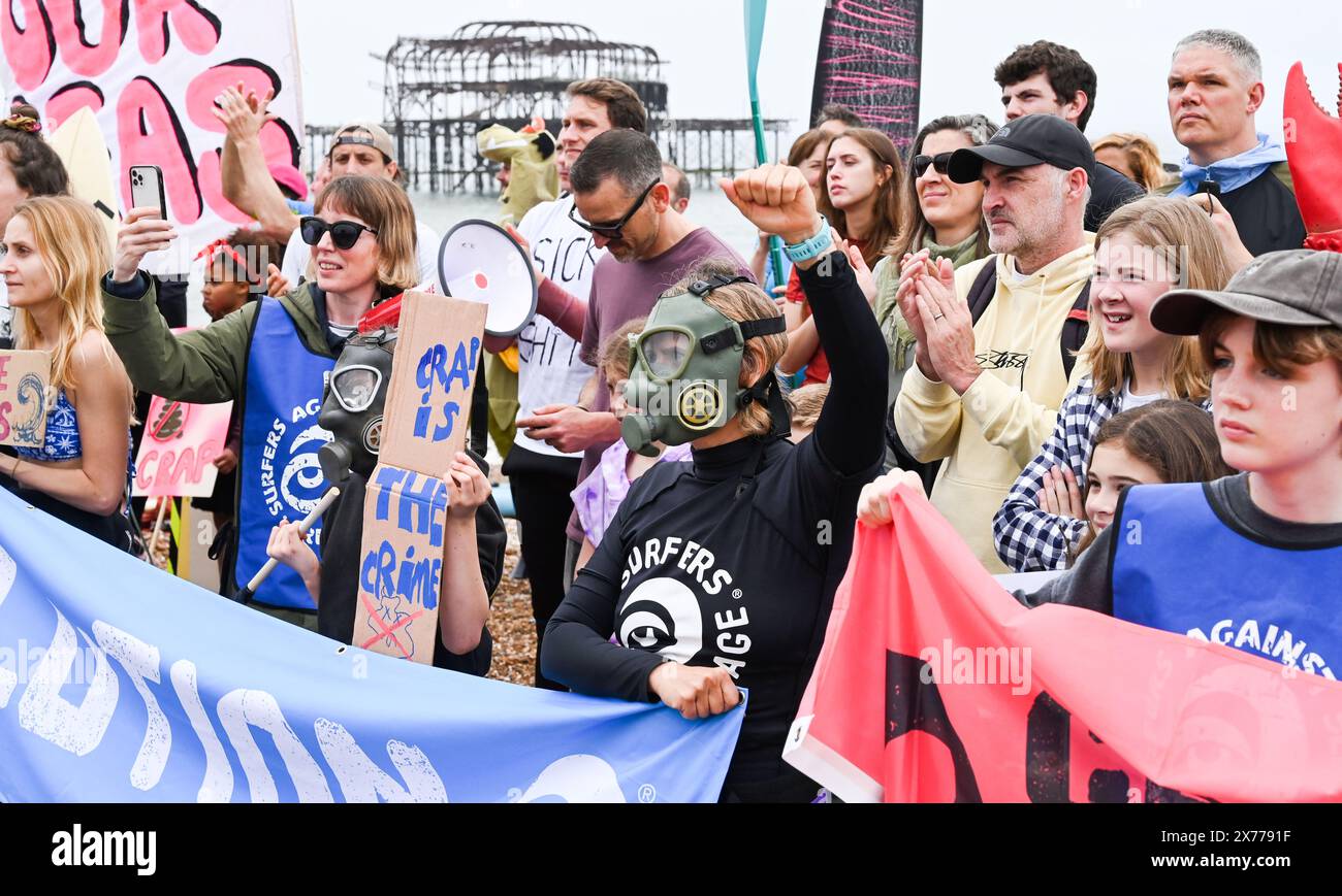 Brighton UK 18 mai 2024 - les Surfers contre les eaux usées protestent aujourd'hui par Brighton West Pier alors que des centaines de planchistes et de nageurs prennent la mer faisant campagne pour que les compagnies d'eau cessent de pomper les eaux usées dans la mer et les voies navigables autour de la Grande-Bretagne . Crédit Simon Dack / Alamy Live News Banque D'Images