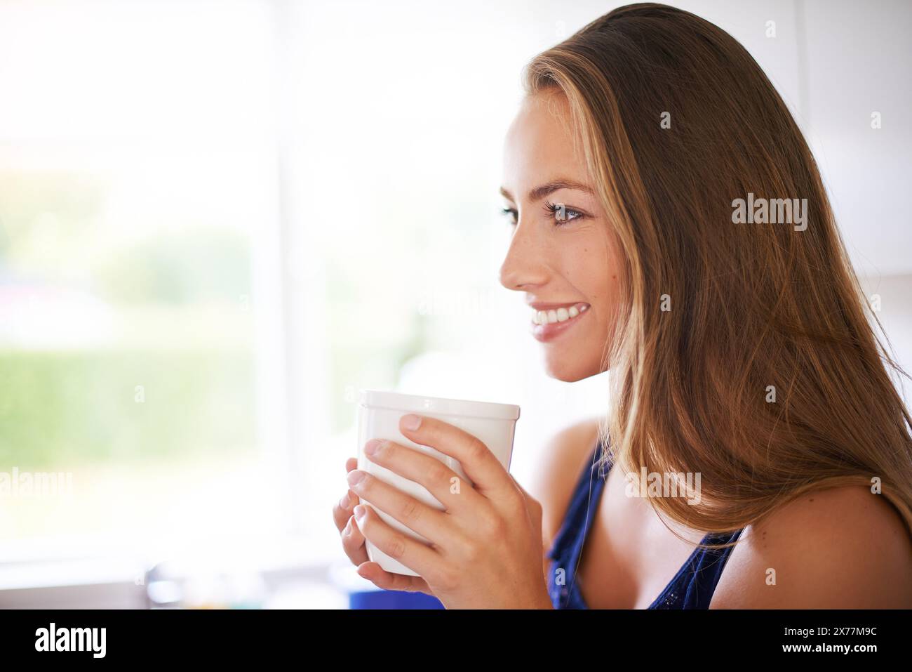 Maison, café et petit déjeuner pour fille, sourire et penser le matin pour se détendre, cuisine et pause. Maison, heureux et femme avec boisson pour profiter, boire Banque D'Images