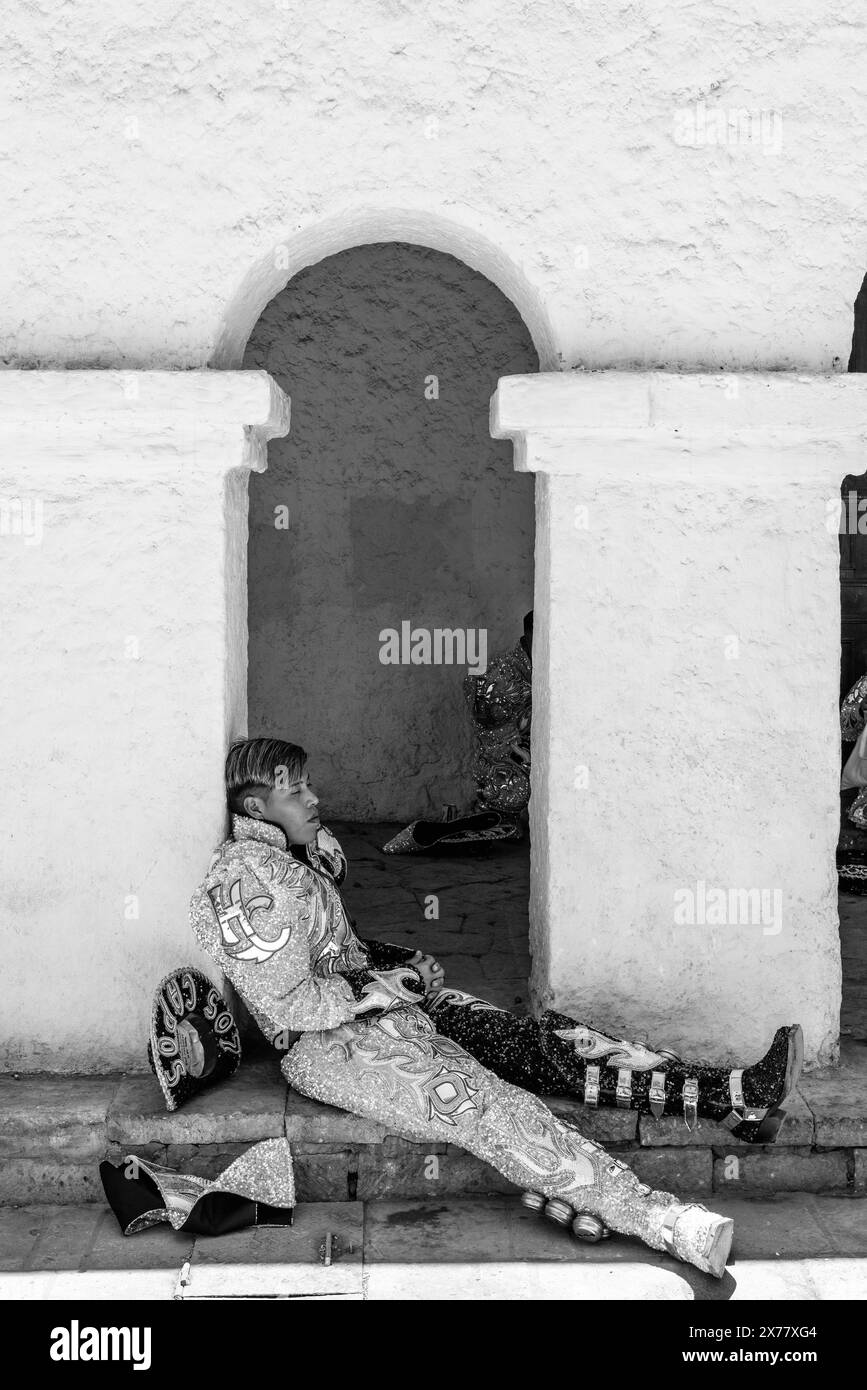 Un jeune homme se reposant à l'ombre pendant la Fiesta de la Virgen de la Candelaria, San Pedro de Atacama, région d'Antofagasta, Chili. Banque D'Images