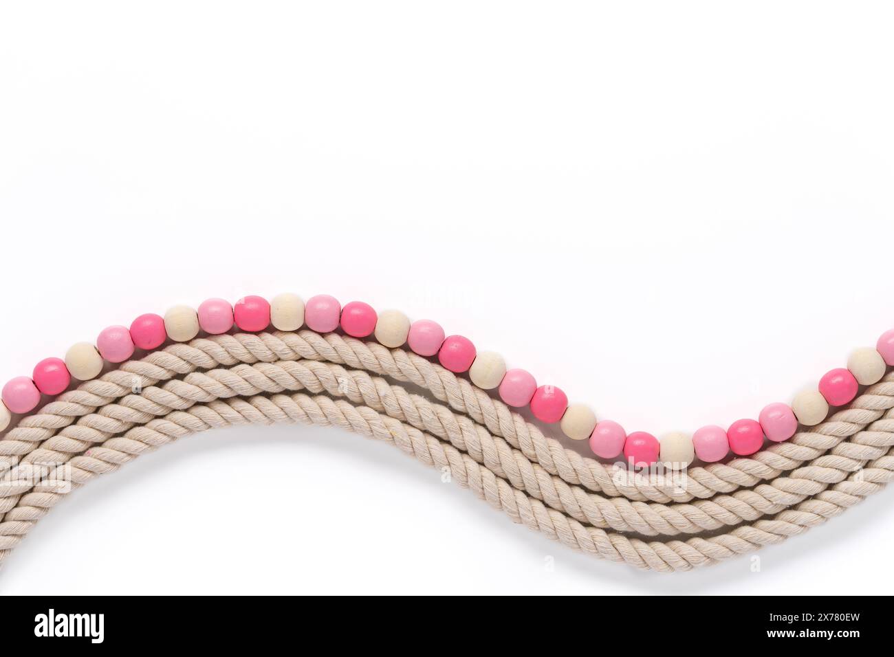corde texturée épaisse ondulée et bordure de perle en bois lisse dans les tons de blanc cassé et rose sur un fond blanc Banque D'Images