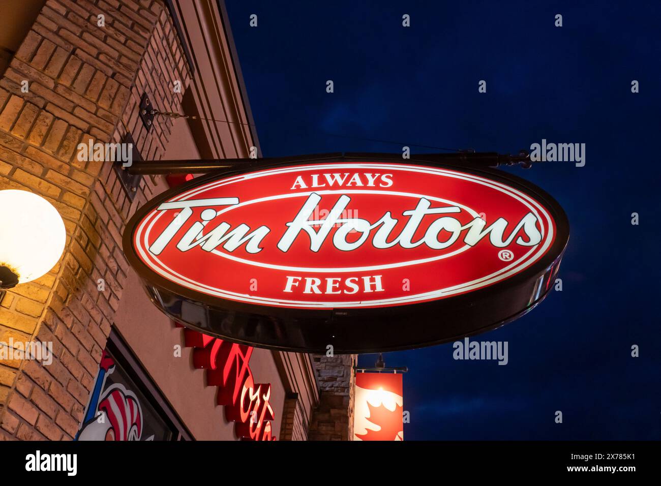 Logo Tim Hortons sur le bâtiment au crépuscule. Niagara Falls, Ontario, Canada, le 8 décembre 2023. Banque D'Images