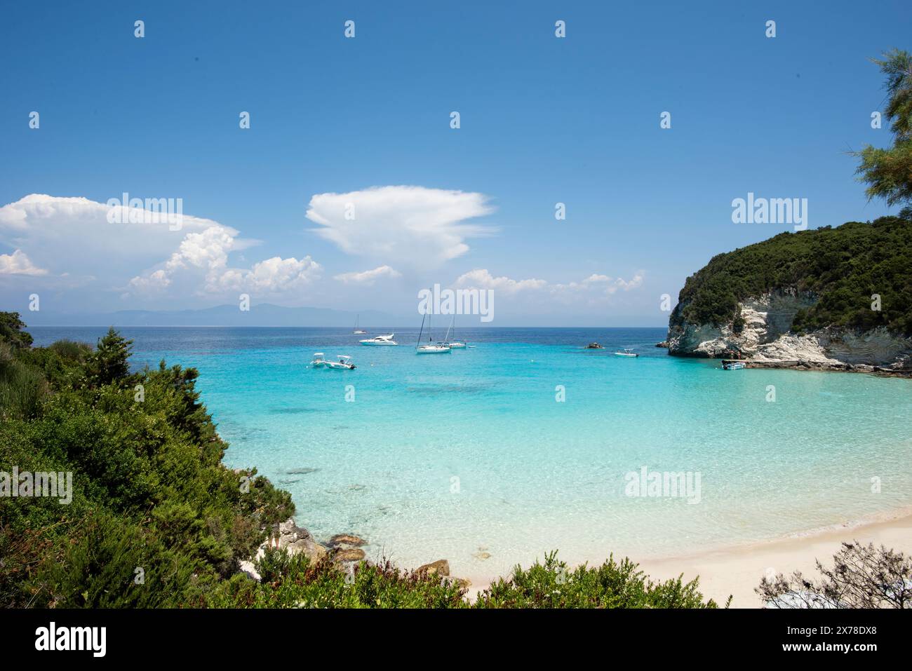 Vue panoramique sur une baie rocheuse sur une île en Grèce avec des bateaux ancrés, la côte avec beaucoup de végétation et la mer Méditerranée. Voyage et visite Banque D'Images